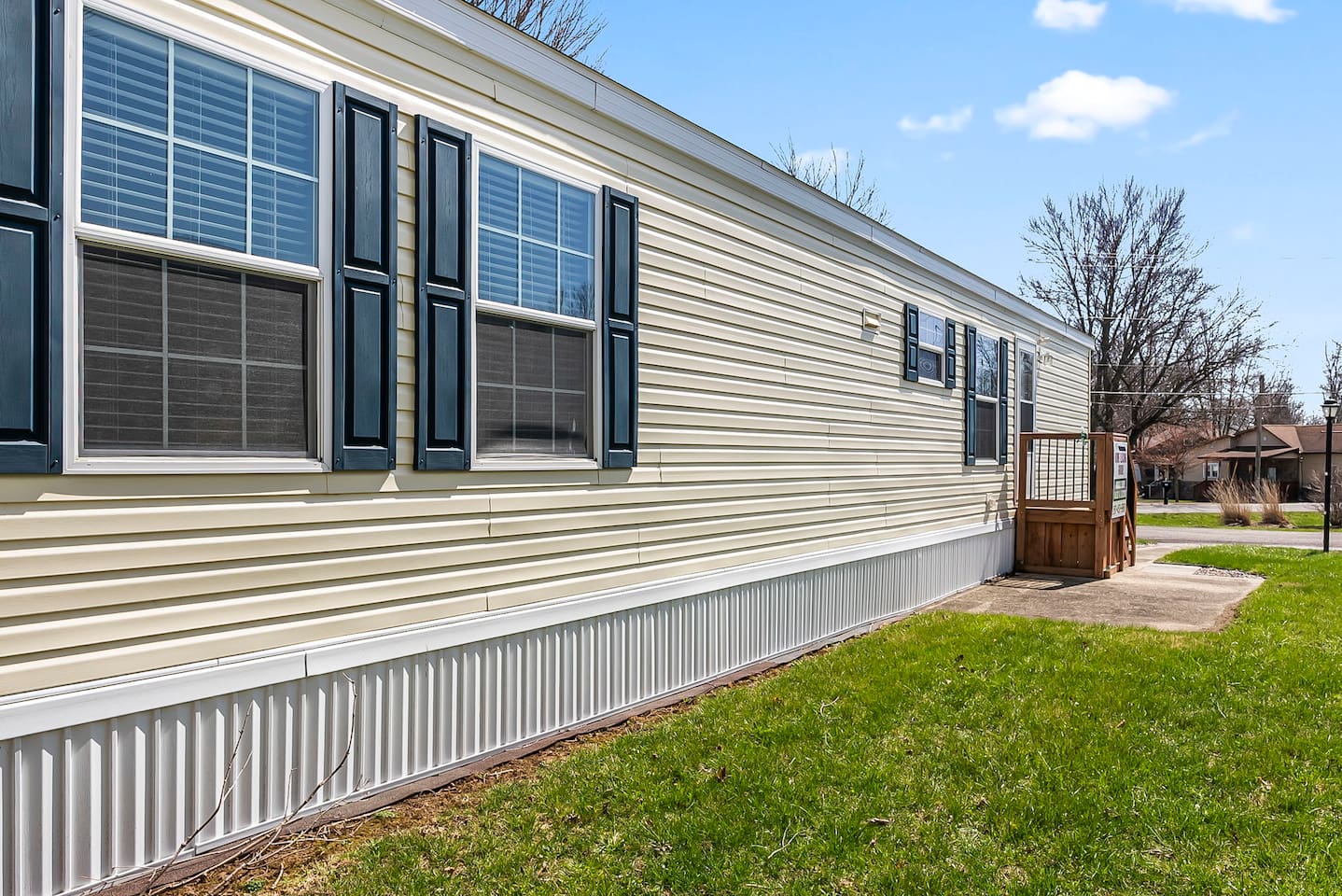 Side view highlighting the home’s length, multiple windows, and private entry steps.