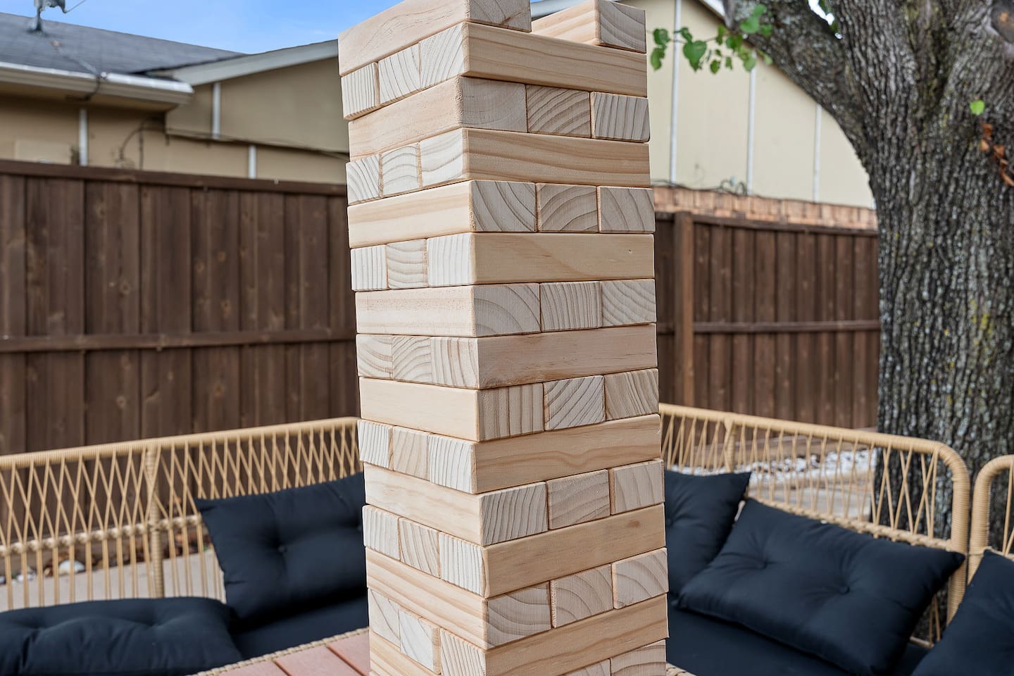 Enjoy outdoor fun with a giant Jenga game set up on a patio table. This engaging activity is perfect for gatherings.