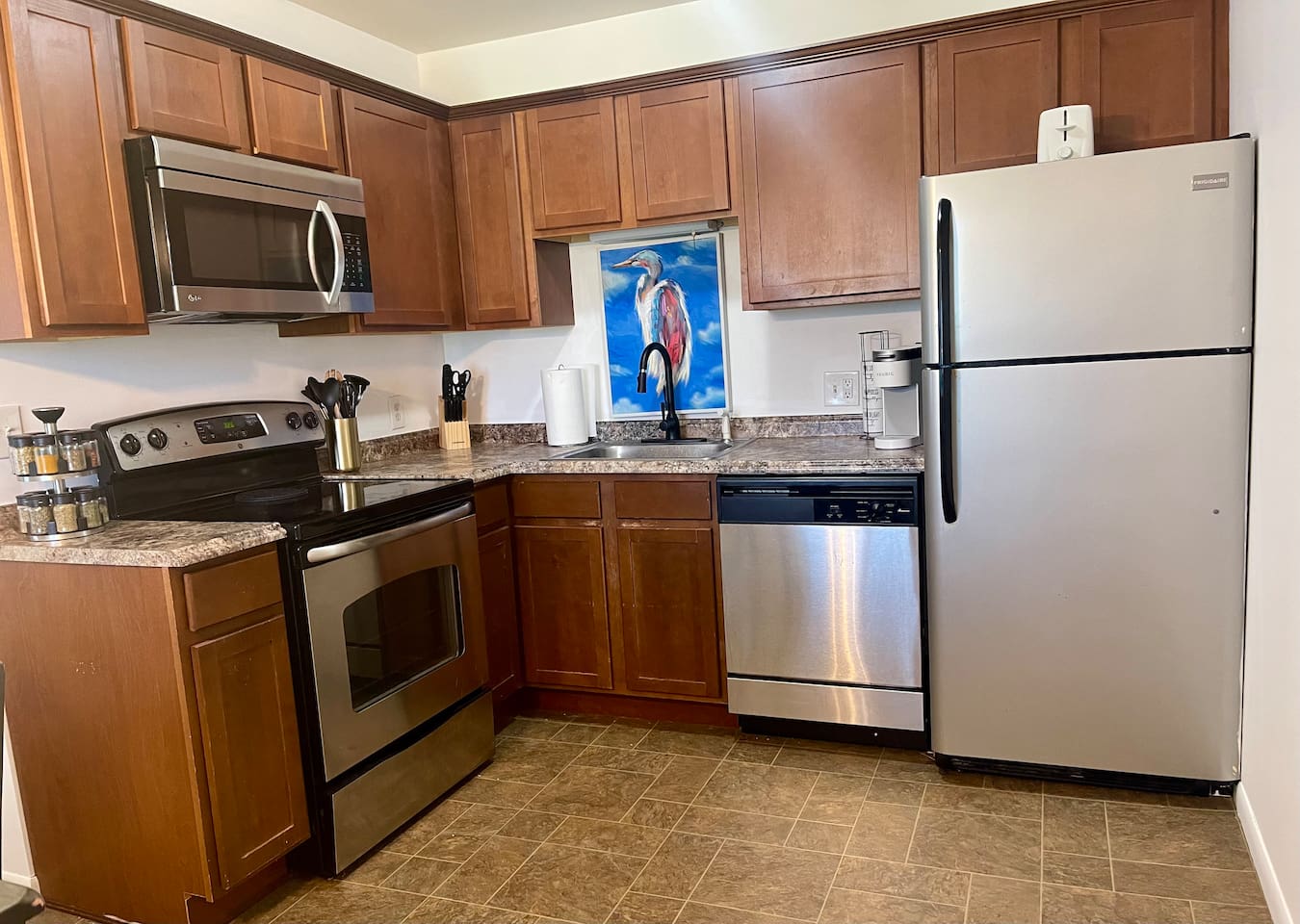 Fully stocked kitchen with stainless steel appliances, spacious counters, a spice rack, Keurig, and modern essentials for home-cooked meals or quick bites. Clean, bright, and functional—perfect for extended stays or cozy nights in.
