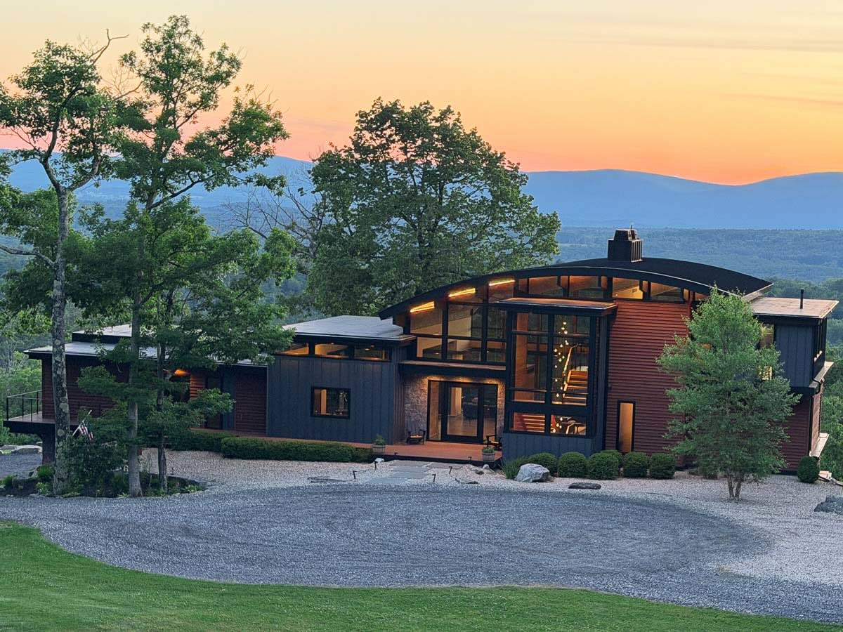 Front of Sunset Falls Estate with the hanging lights seen through the window &mdash; Berkshires