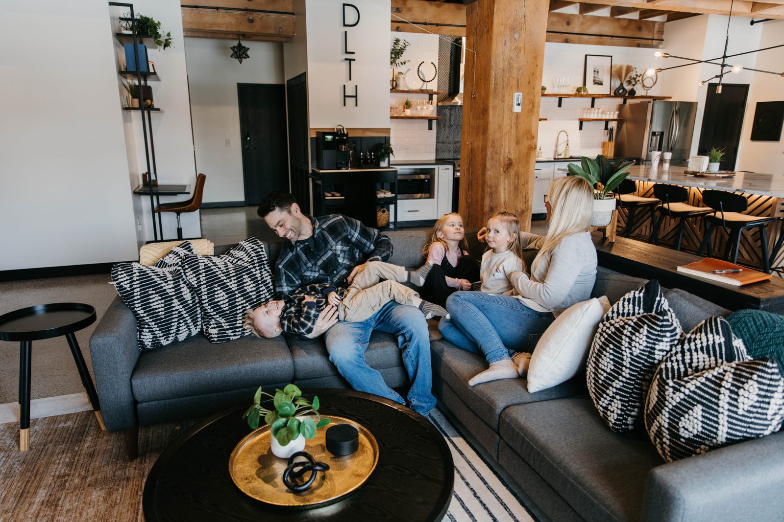 A group relaxing together on a large sectional in a bright Brix condo in Canal Park