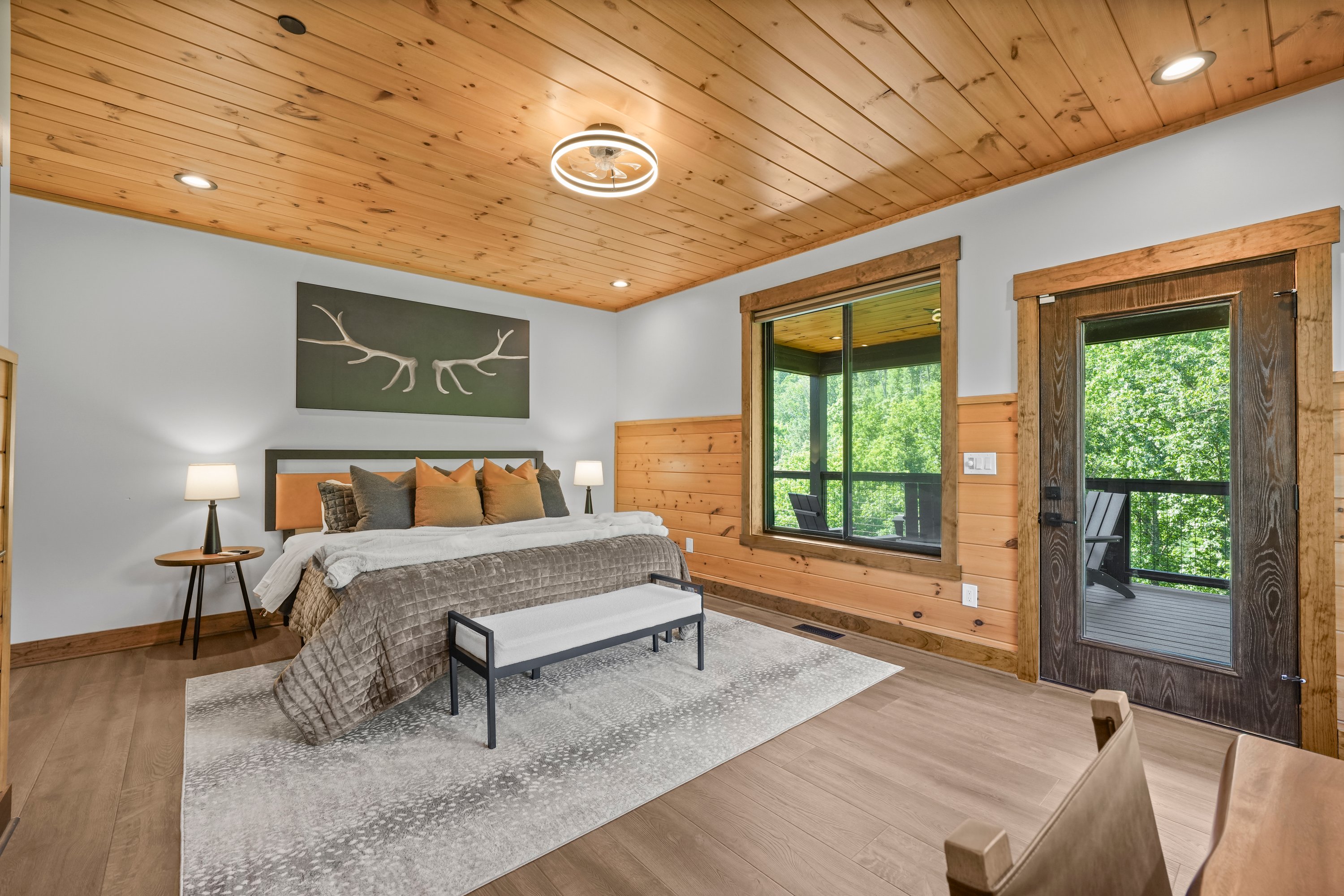 Relax in the spacious king bedroom with a large TV, dedicated desk workspace & direct deck access. Unwind in the en-suite bathroom featuring a walk-in shower with a natural river rock floor, bringing  the Smoky Mountains indoors for a spa retreat.