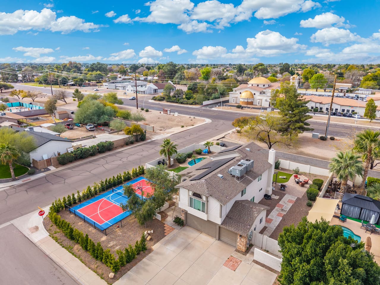 Contemporary home with dedicated sports court, pool, and manicured grounds in established neighborhood.