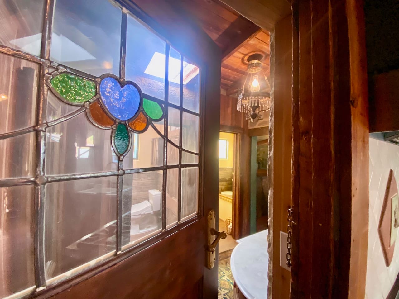 Found forgotten in the shed, this original stained-glass door was restored and returned to service—to separate the kitchen from the dual  powder rooms and laundry area. We love inviting the history back into the story.