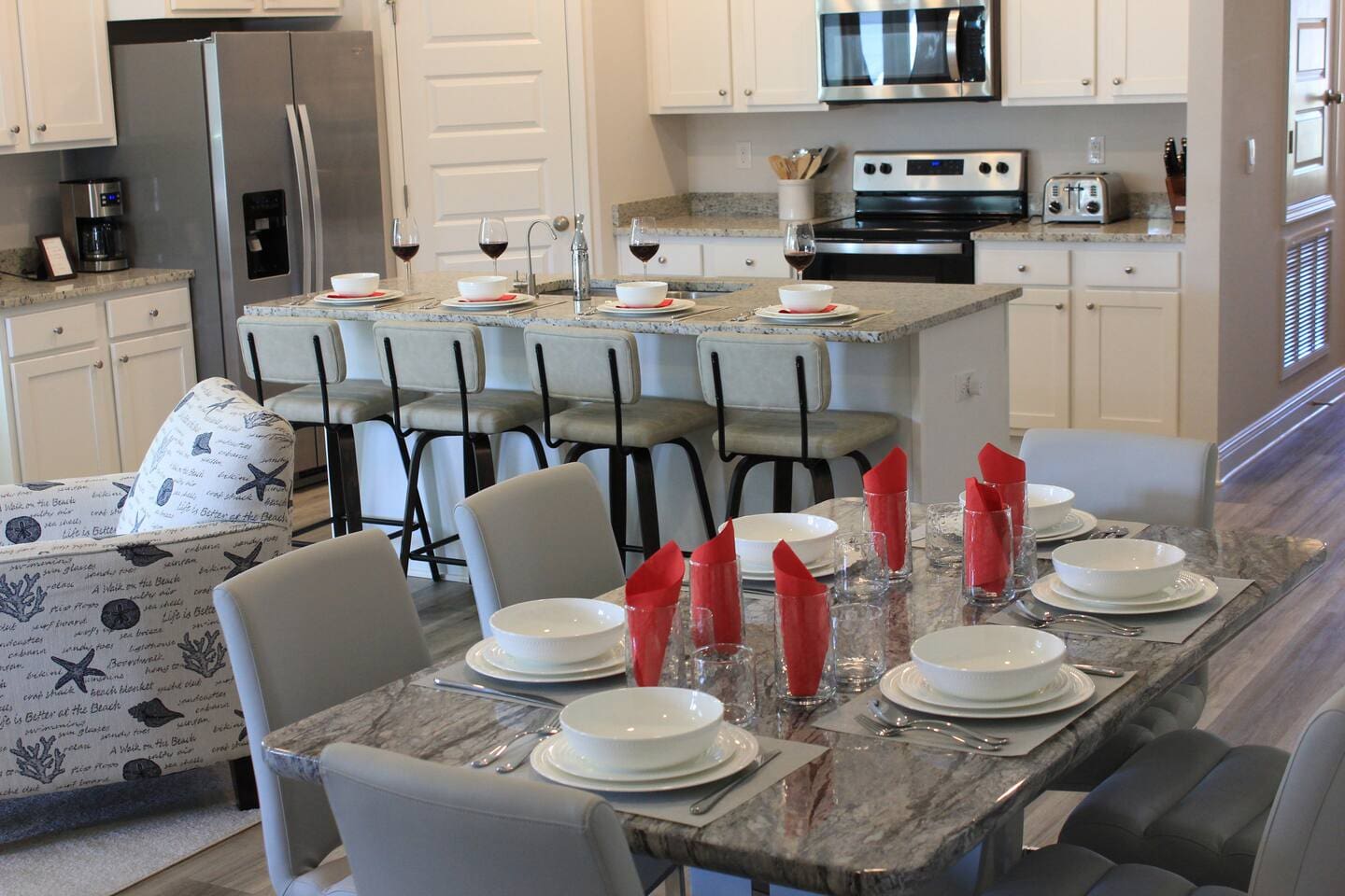 Stylish full kitchen with counter seating, stove, microwave, and open layout connecting dining and living area.