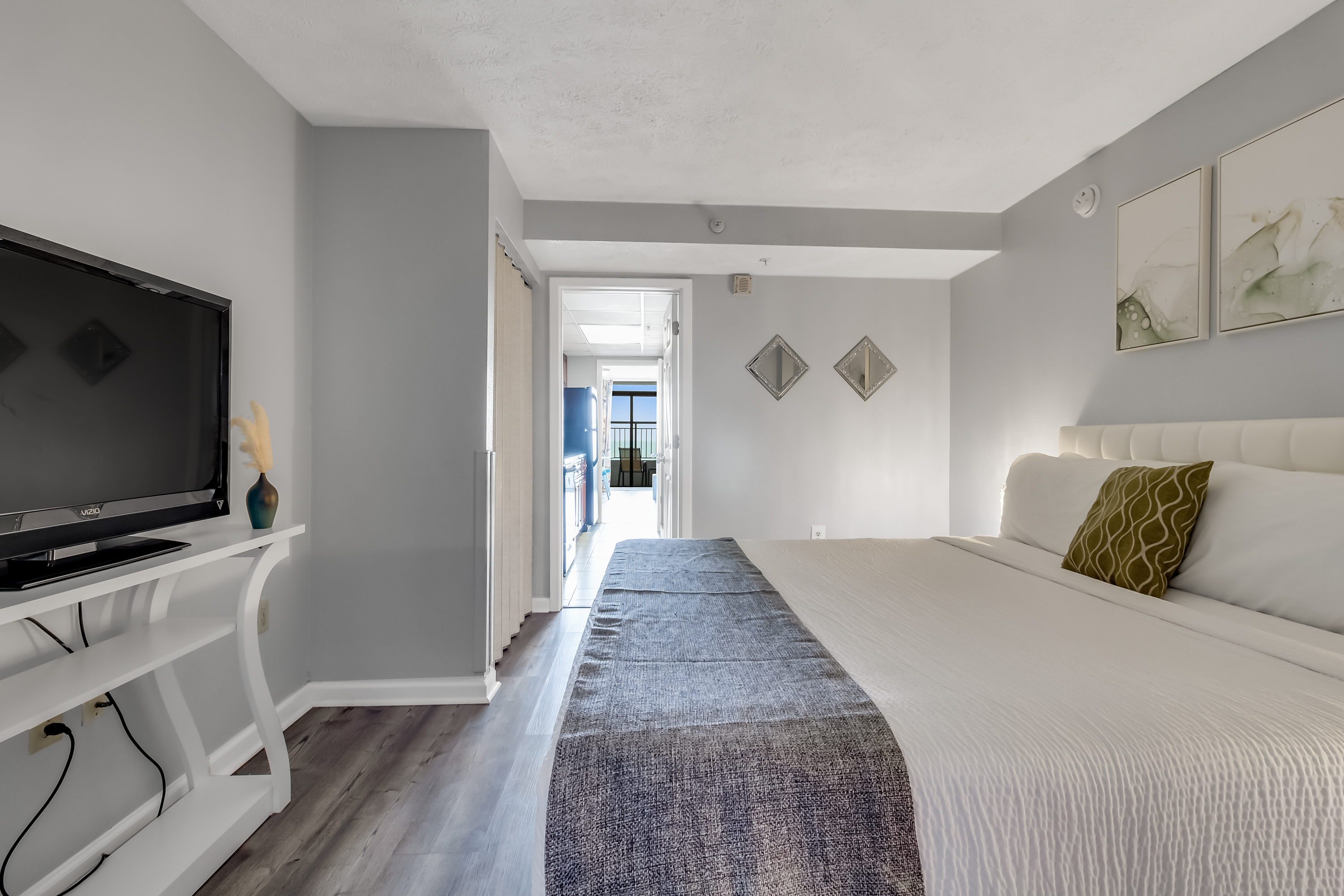 Relax in a spacious and elegantly decorated bedroom with plush bedding and soothing coastal tones.