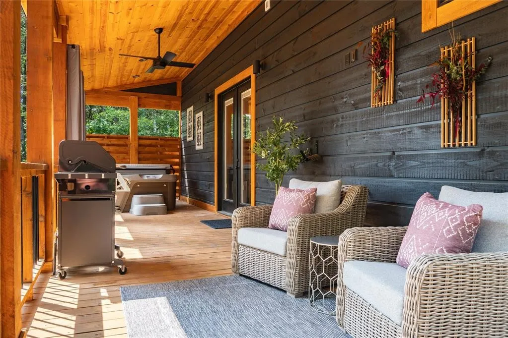 Back deck has cozy seating for 2, a therapeutic hot tub and gas grill.