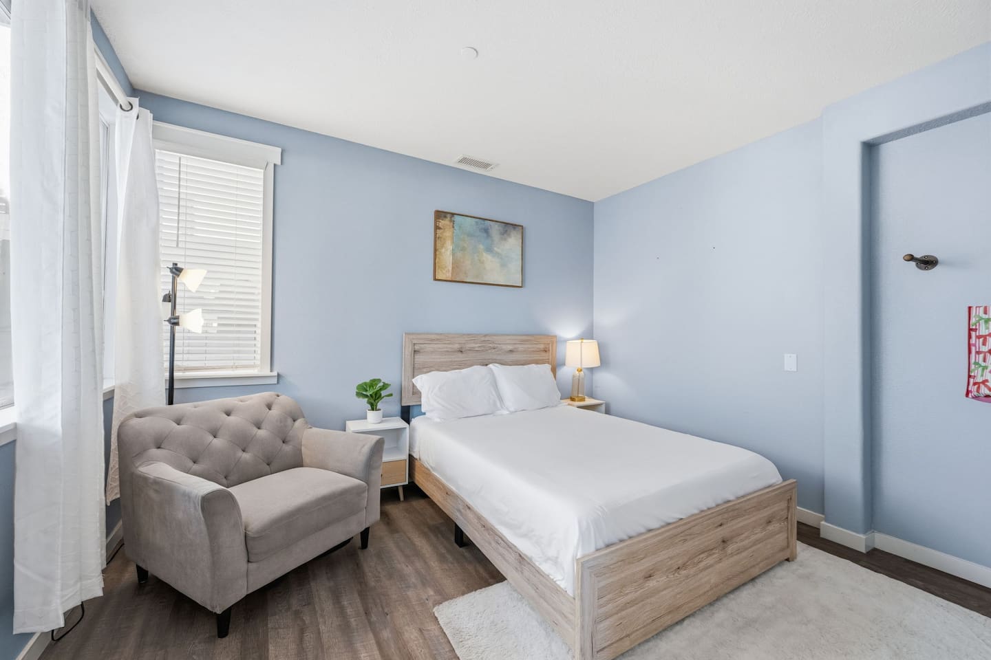 Bedroom 4 with full bed, extra pillows, blankets, and clothing storage. Light and airy with a seating area for added comfort.