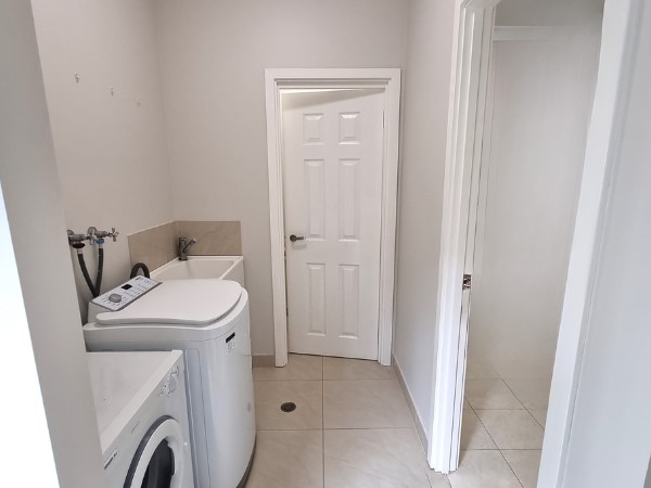 Spacious laundry area with washing machine, clothes dryer and the separate 2nd toilet