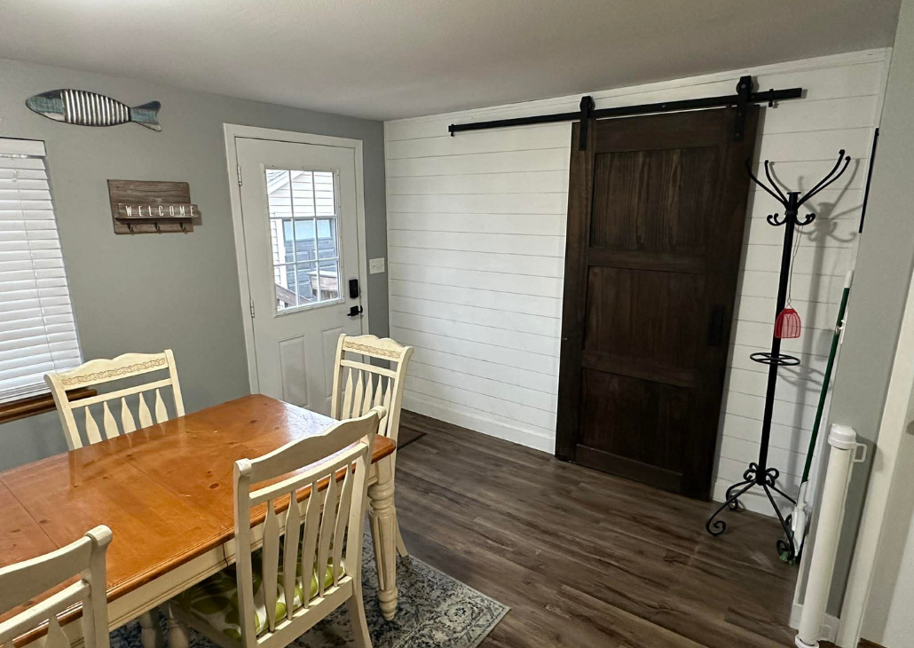 View of the back door that leads to the back deck + grill.
