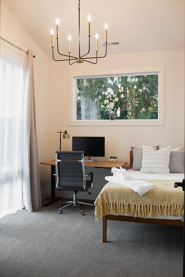 This room is on the main floor, featuring a work area and a single plush mattress bed.