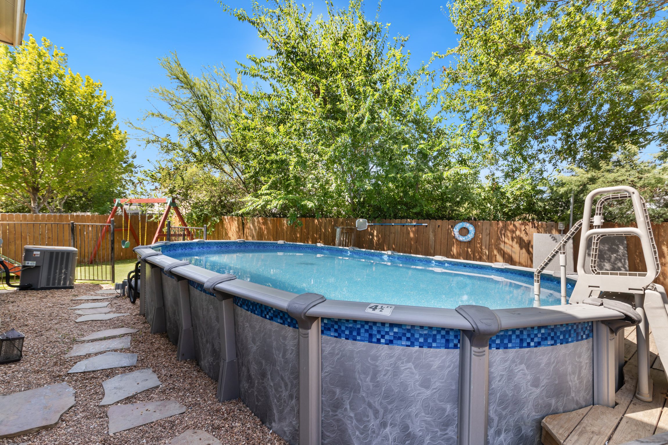 Private above-ground pool with stepping stone patio in a fully fenced backyard. Crystal clear water, ladder access, and patio lounging — exclusive to your group of up to 10 in Northeast San Antonio.