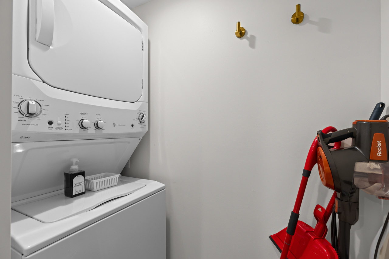 Convenient in-unit washer and dryer with nearby wall hooks and space for cleaning essentials—making longer stays easy and comfortable.
