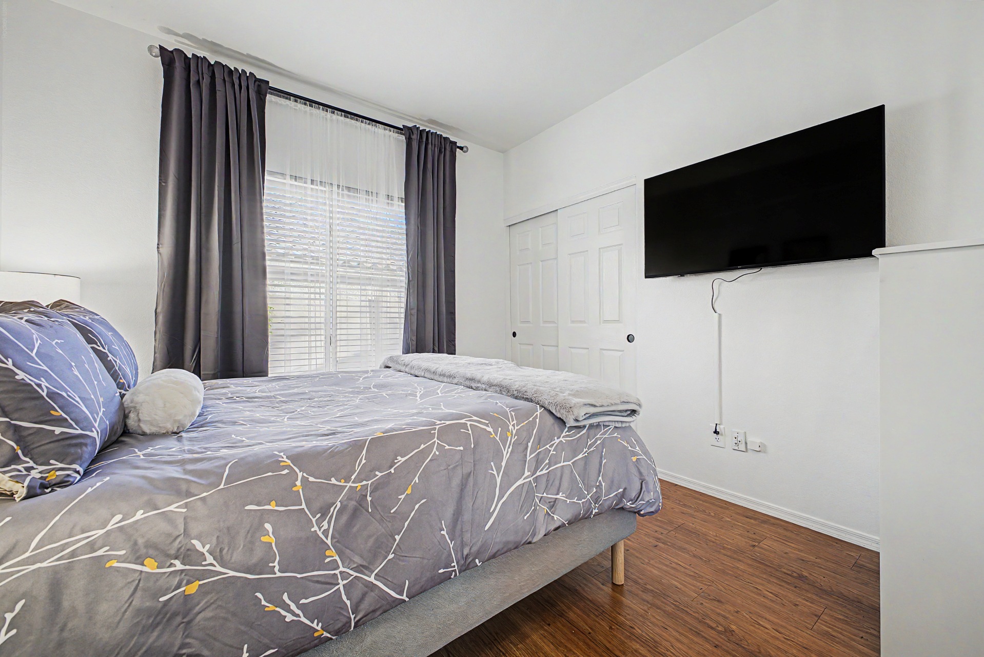 Queen bedroom downstairs with 55" Smart Tv and blackout curtains