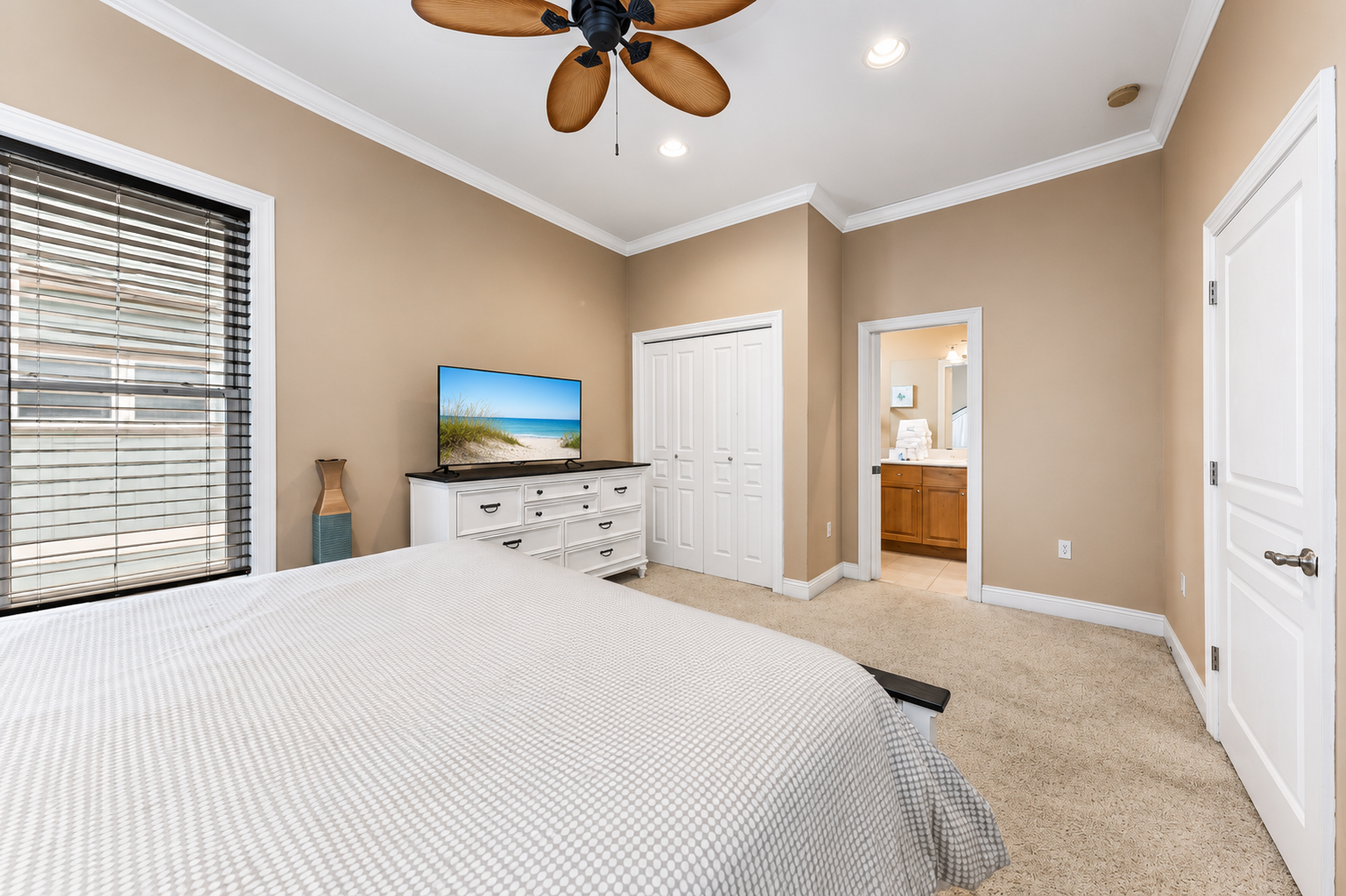 Bedroom with en-suite bathroom access, smart TV, and ceiling fan