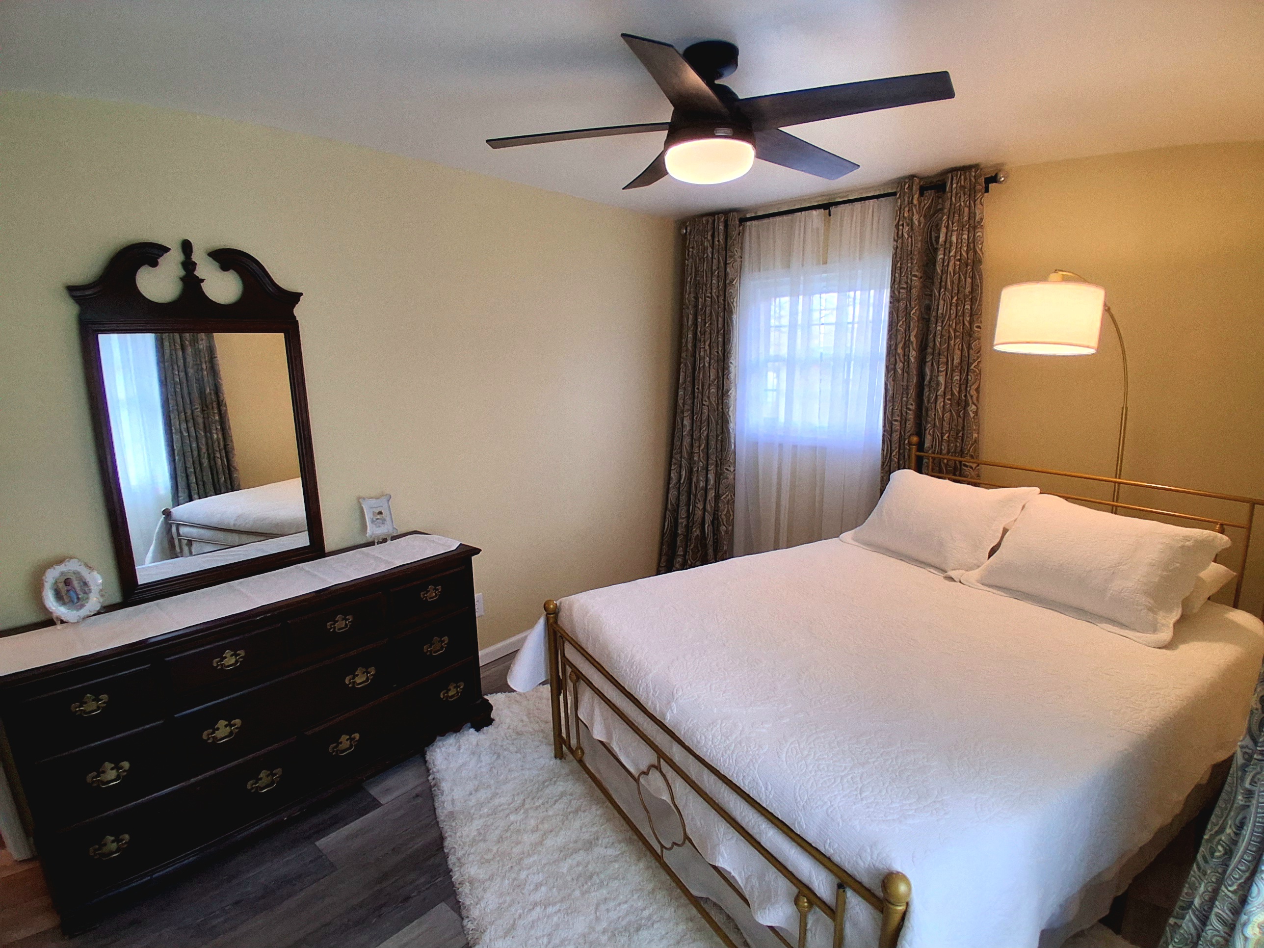 Both bedrooms offer privacy with their own lock and key. The cherry dresser provides generous drawer space, and the closet offers plenty of room for your belongings. A plush shag rug adds a cozy, welcoming touch underfoot.