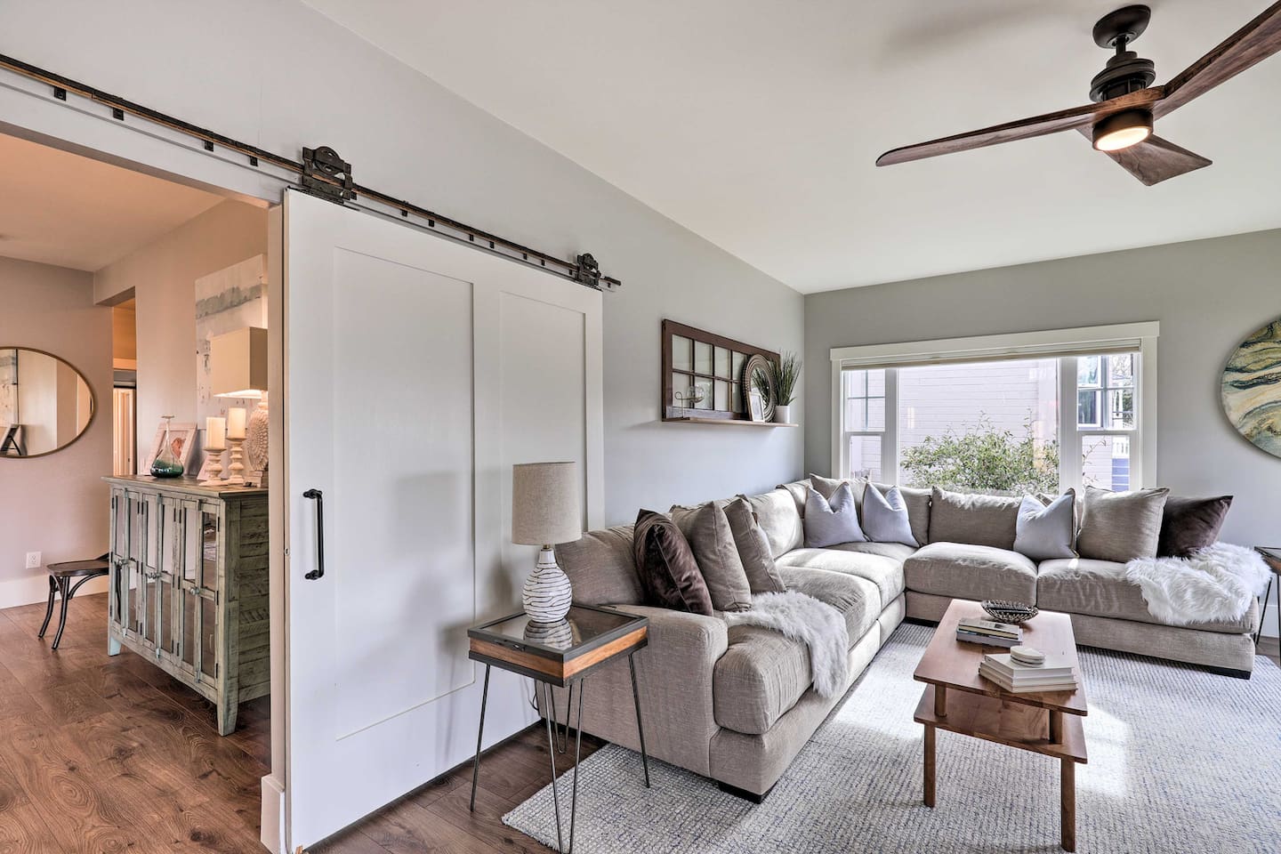 A sliding barn door adds character to this bright, airy living space.