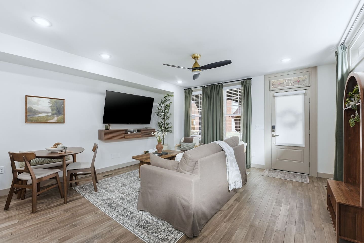 Cozy dining area with a stylish round table and seating for four, perfectly positioned next to the open-concept living space—ideal for enjoying meals, morning coffee, or casual gatherings.