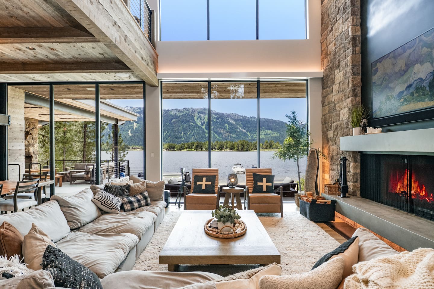 This spacious living room offers unbeatable lake views, a stone fireplace, and tons of cozy seating, ideal for relaxing after a day on the water