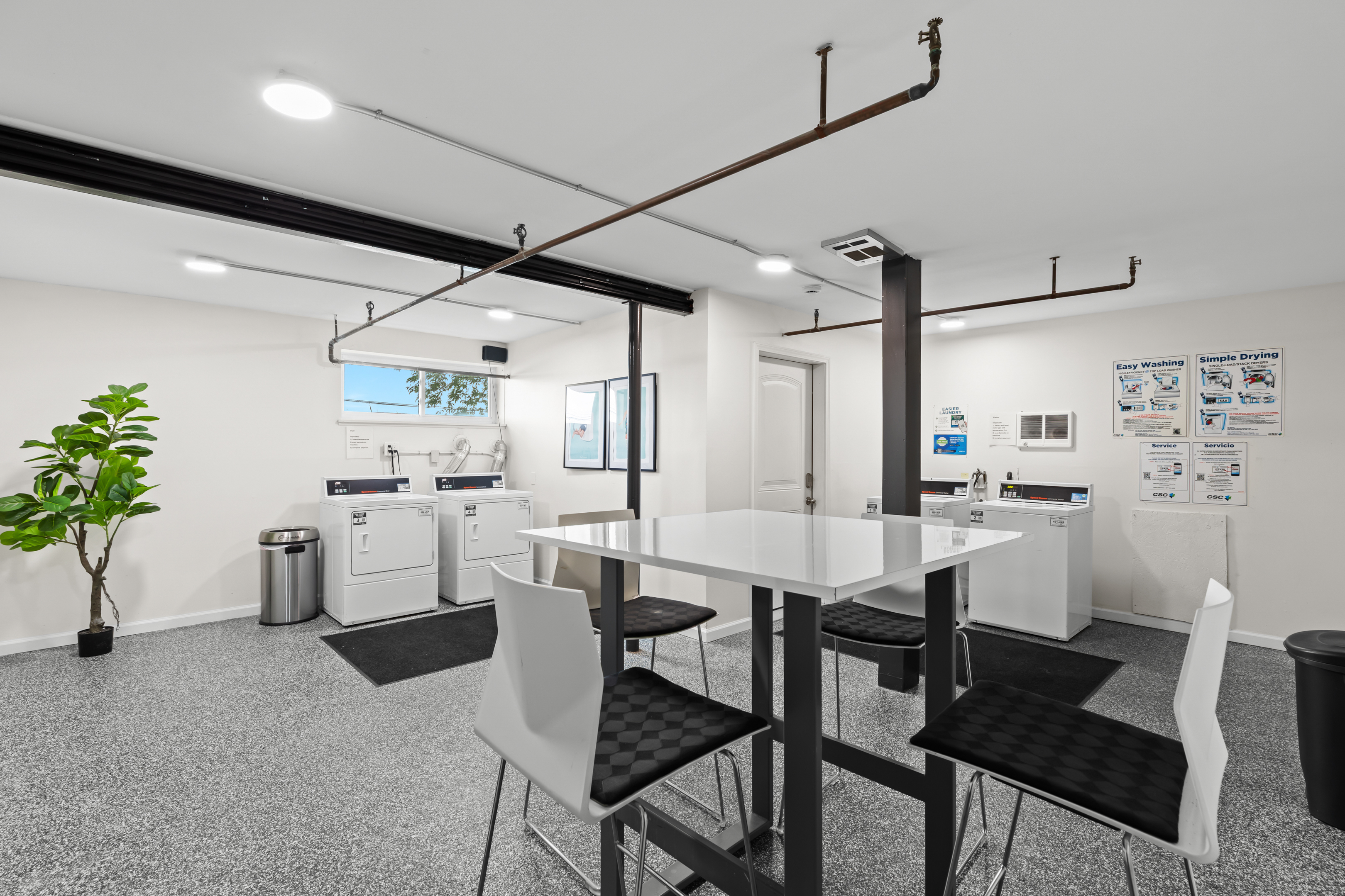 Shared laundry room with folding station and updated appliances for guest convenience.