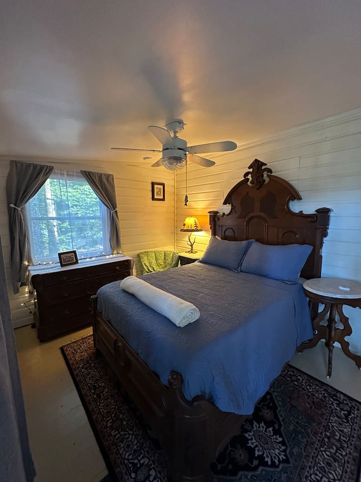 Rest easy in the main double  bedroom, complete with soft linens, blackout curtains, and charming cabin views. Quiet, private, and ideal for a good night’s sleep after a day outdoors.