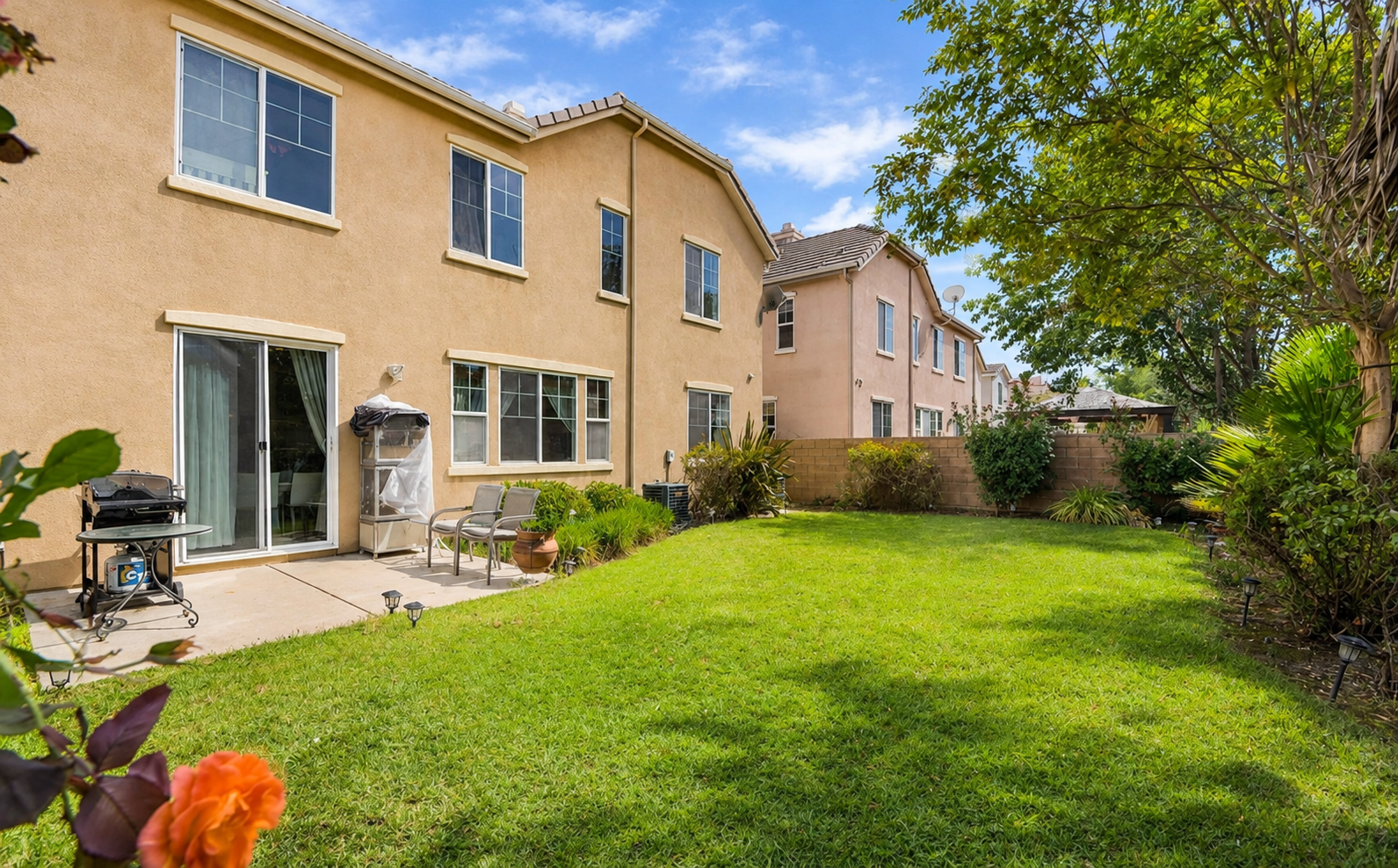 Backyard with a grassy lawn, patio seating, and plenty of space to enjoy the fresh air.