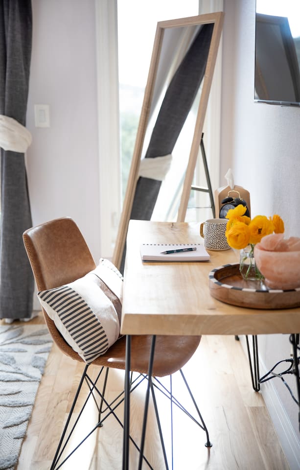 This inviting king bedroom features a dedicated desk and chair—perfect for catching up on work while enjoying natural light and beautiful mountain views. Step out onto the private balcony for a peaceful break between meetings or adventures.