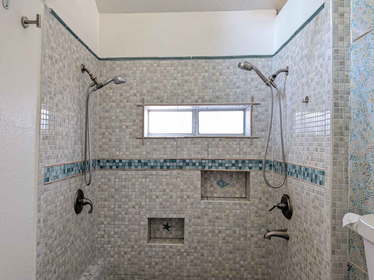 Spacious walk-in shower with dual showerheads. 🚿