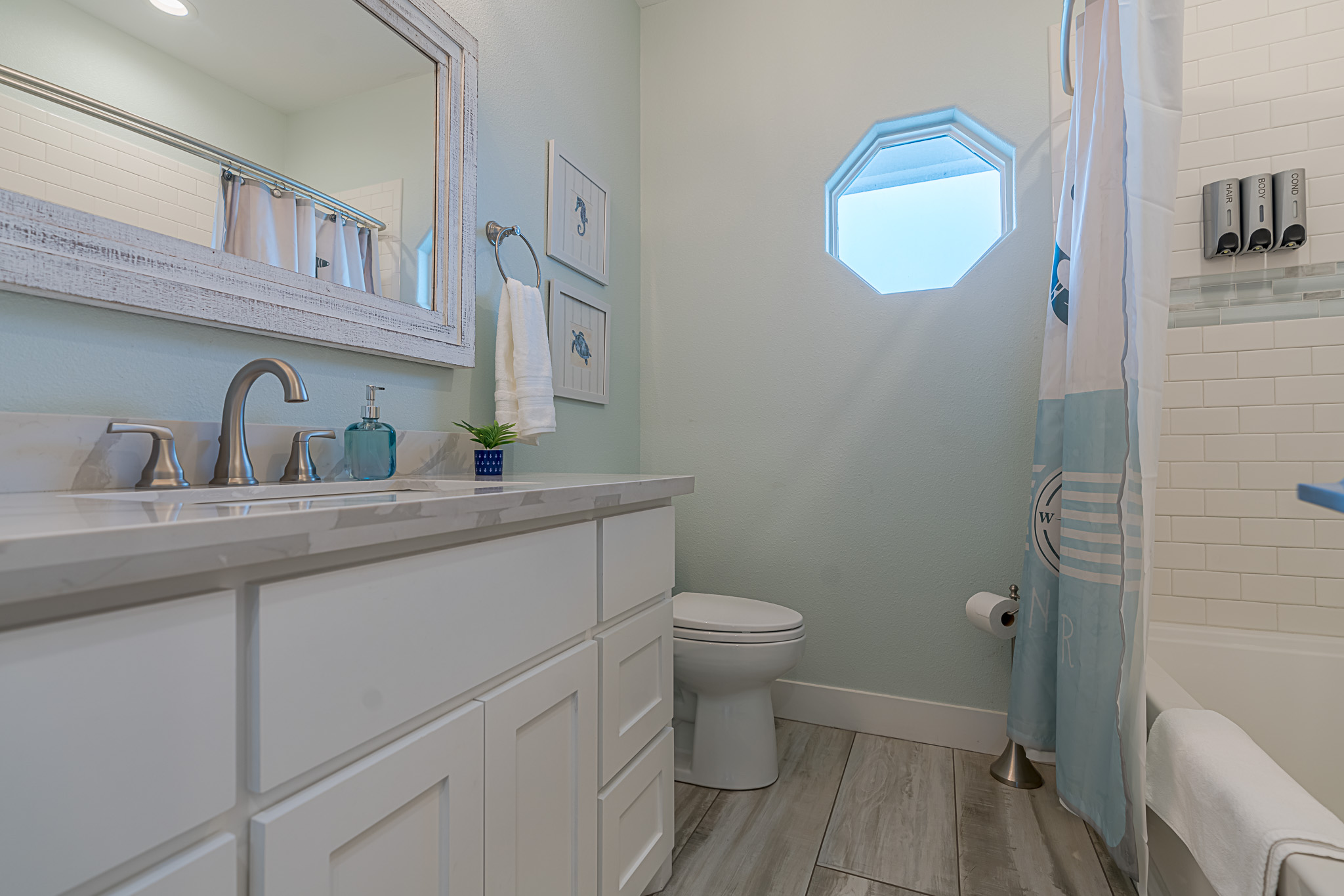 Full bathroom off the kitchen hallway. Each shower is equipped with shampoo, conditioner, and body wash.