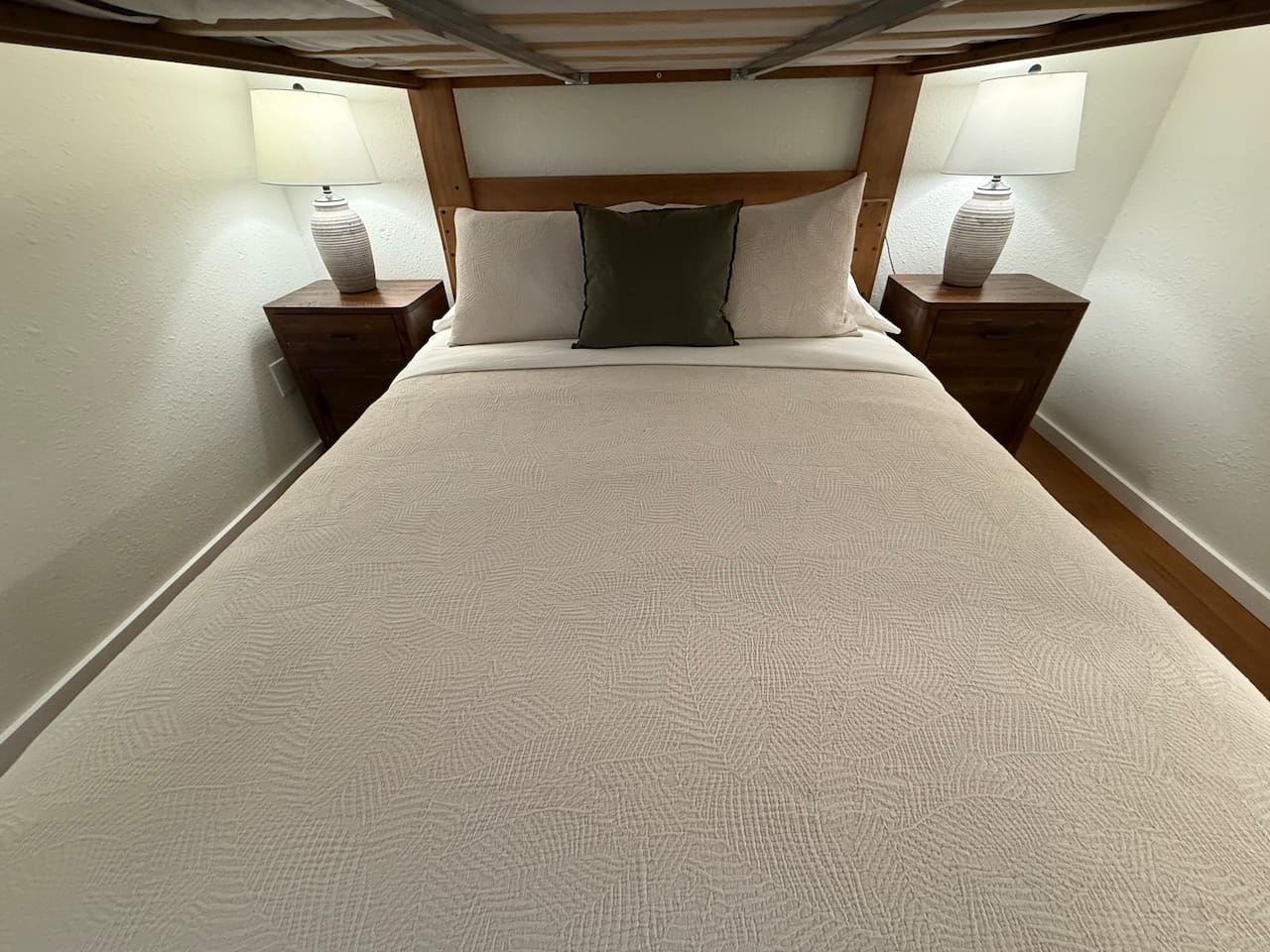 Nightstands with a lamp and electrical outlets and USB outlets on either side of the bed. 