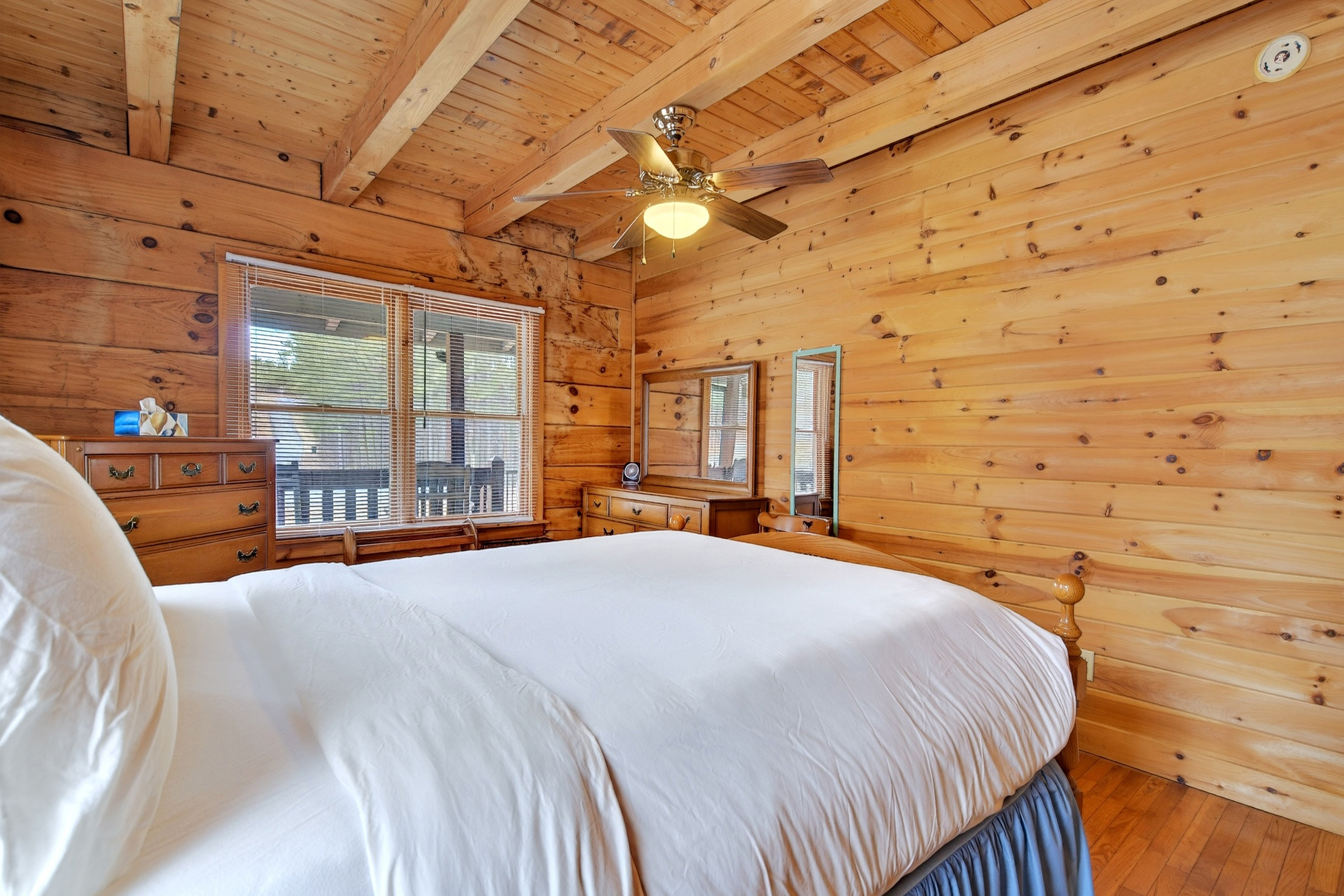 Large windows and a ceiling fan in the main level bedroom 