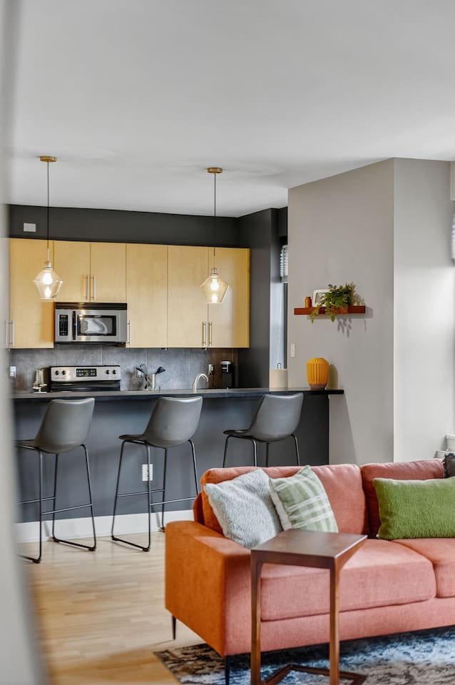 Gather around the stylish breakfast bar with seating for three. Perfect for morning coffee, casual meals, or evening cocktails, all while overlooking the bright, modern living space.