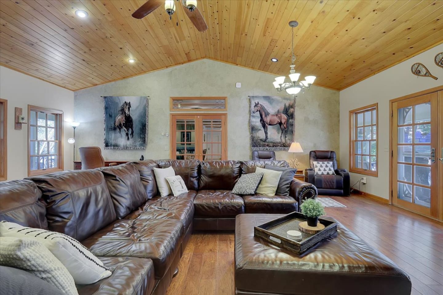 Living room with leather seating, wood ceilings, and plenty of space to gather.
