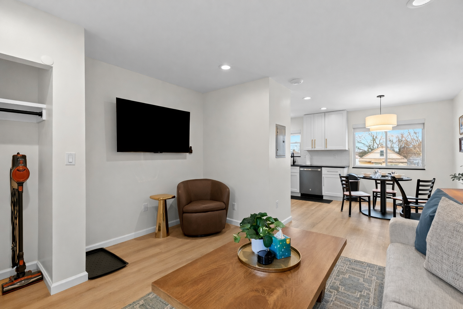 Open, airy living space with cozy seating, smart TV, and a seamless flow into the kitchen and dining area—ideal for relaxing or entertaining.
