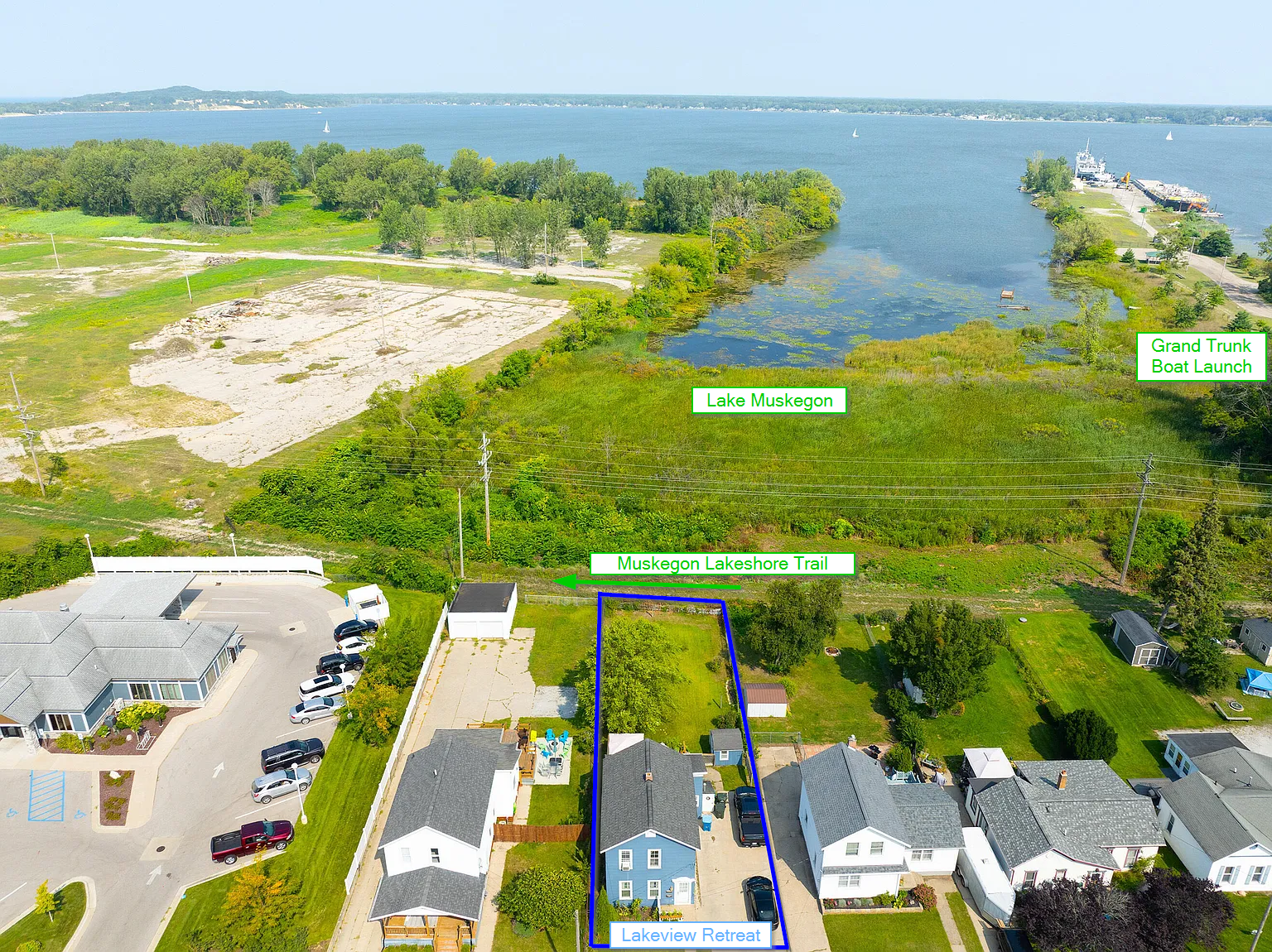 The home backs onto Lake Muskegon, the Muskegon Lakeshore Trail, and a boat launch right next door (with a big driveway to park your boat!)