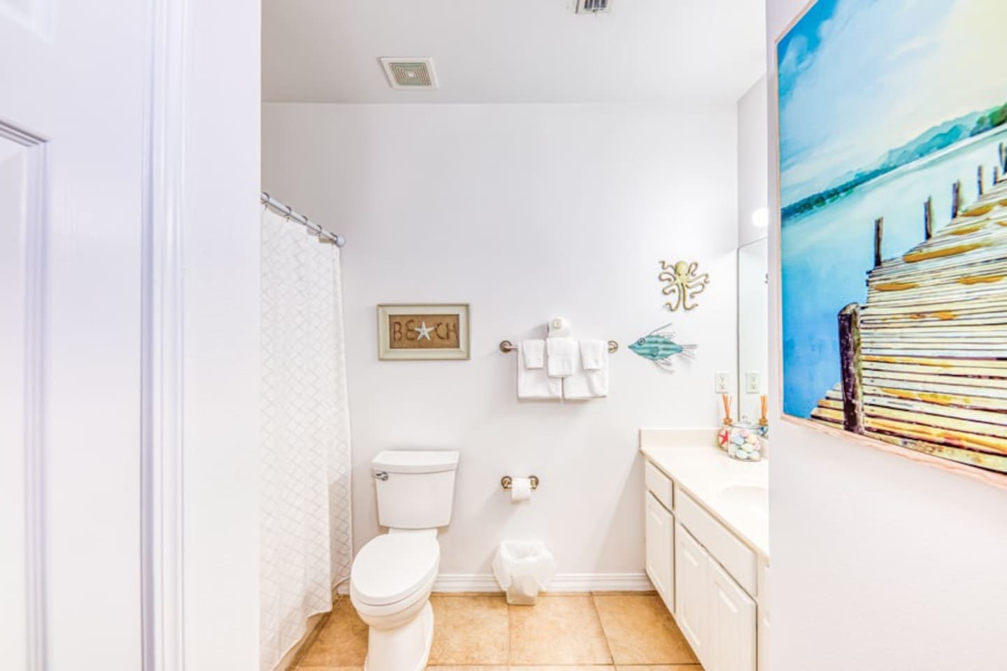 Bathroom Bliss: Refresh in this bright, beach-themed space with stylish decor and ample amenities!