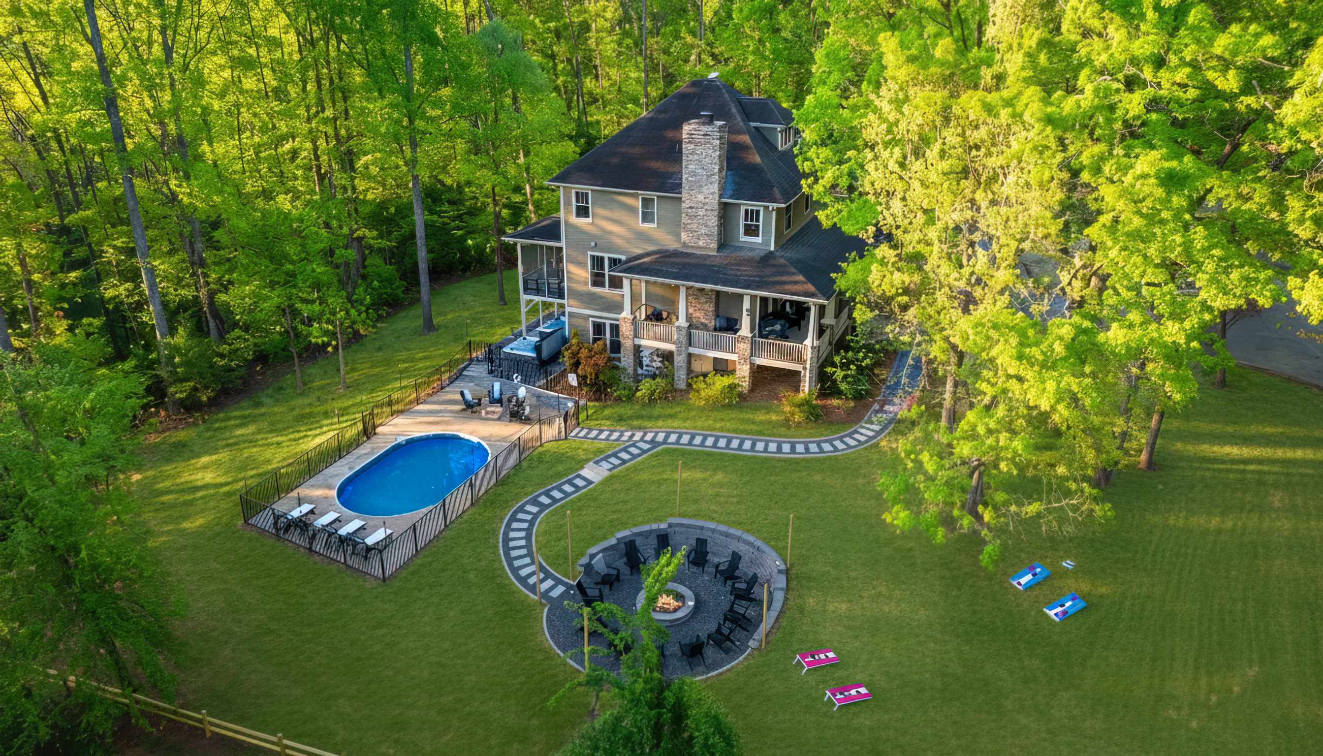 Tucked into the forest with seasonal mountain views, this luxury 8-bedroom retreat sleeps 22 and features a private pool, massive fire pit, 2 hot tubs, outdoor games, a game room, 2 kitchens, 6 king bedrooms & 5 ensuite bathrooms just outside Asheville NC.