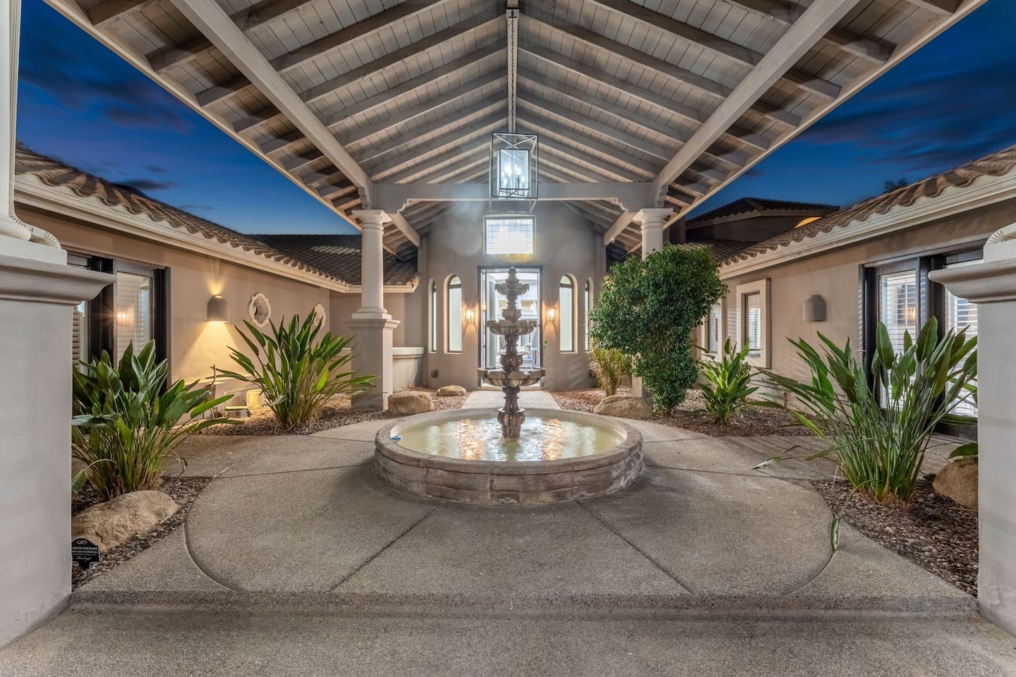 A covered walkway leads to the main entrance, centered around a peaceful fountain—setting the tone for a luxury stay.

