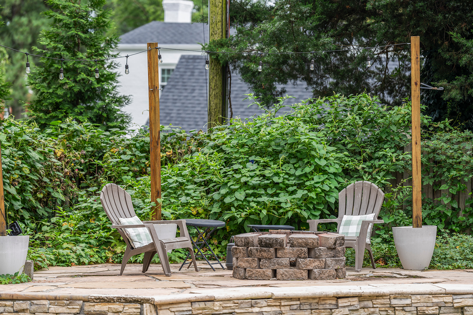 Outdoor Retreat: Unwind by the fire pit amidst lush greenery and twinkling lights!