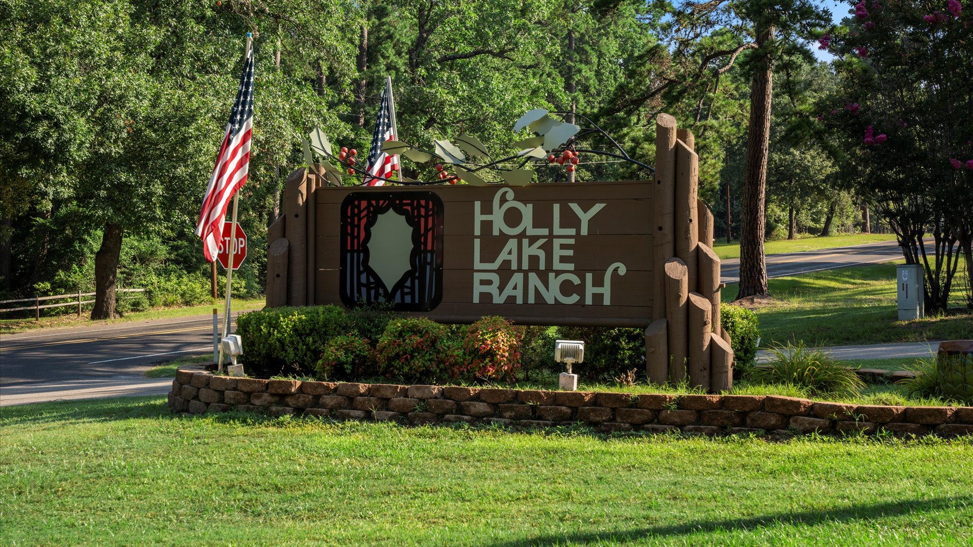 As you arrive, you’ll be greeted by the 'Welcome to Holly Lake Ranch' sign—a rustic, charming marker nestled among tall pines.