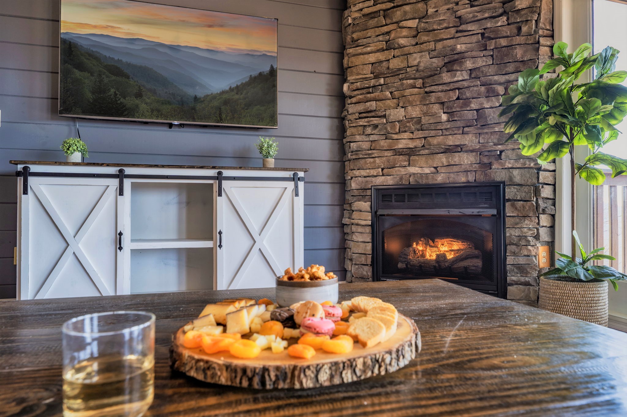 Cozy and spacious living room with a view with modern and traditional cabin decor. Furnished with a 65" Smart TV, 2 big comfy sofas, a fireplace.