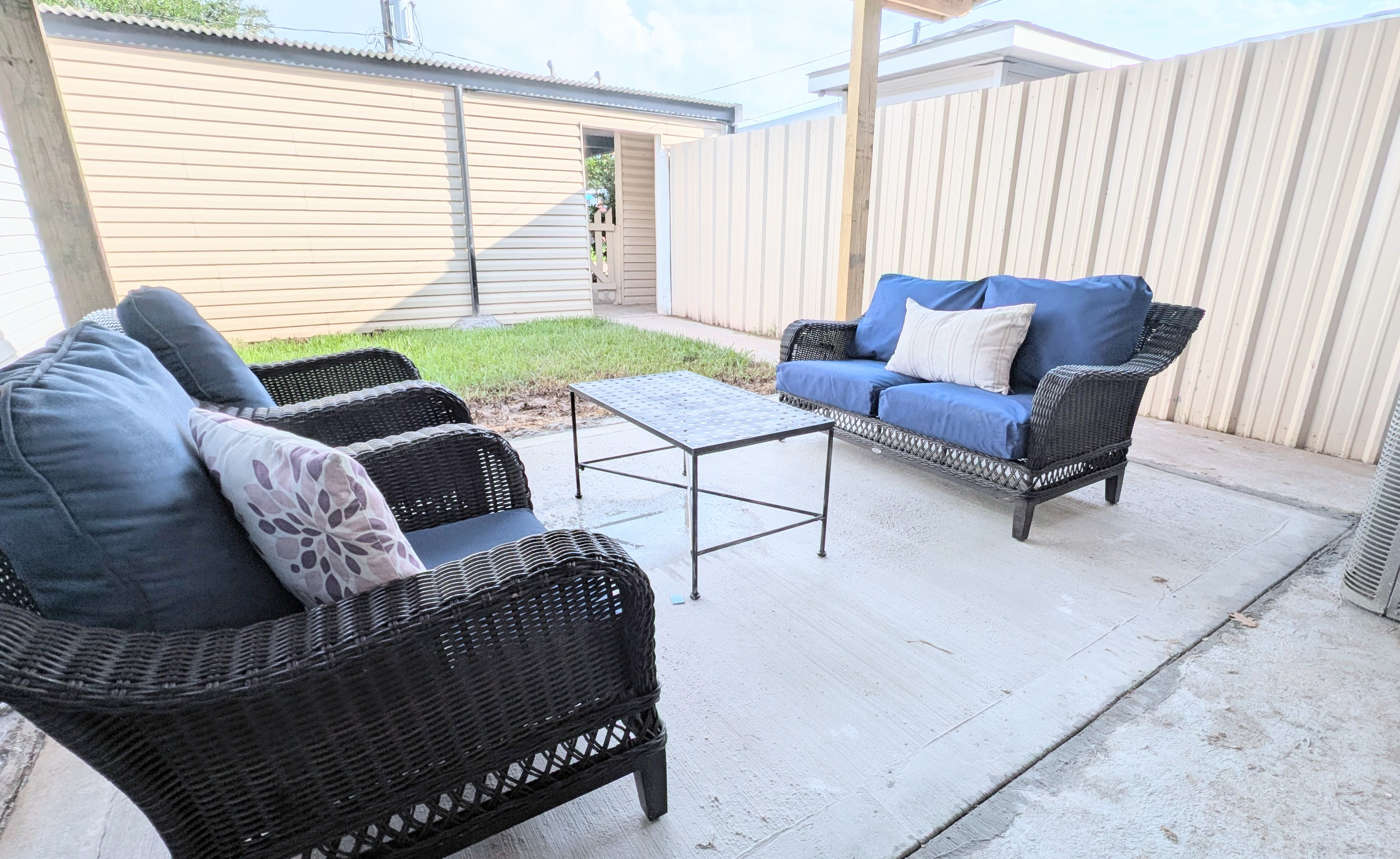 Relax on the covered patio with plush seating and a fenced courtyard. 