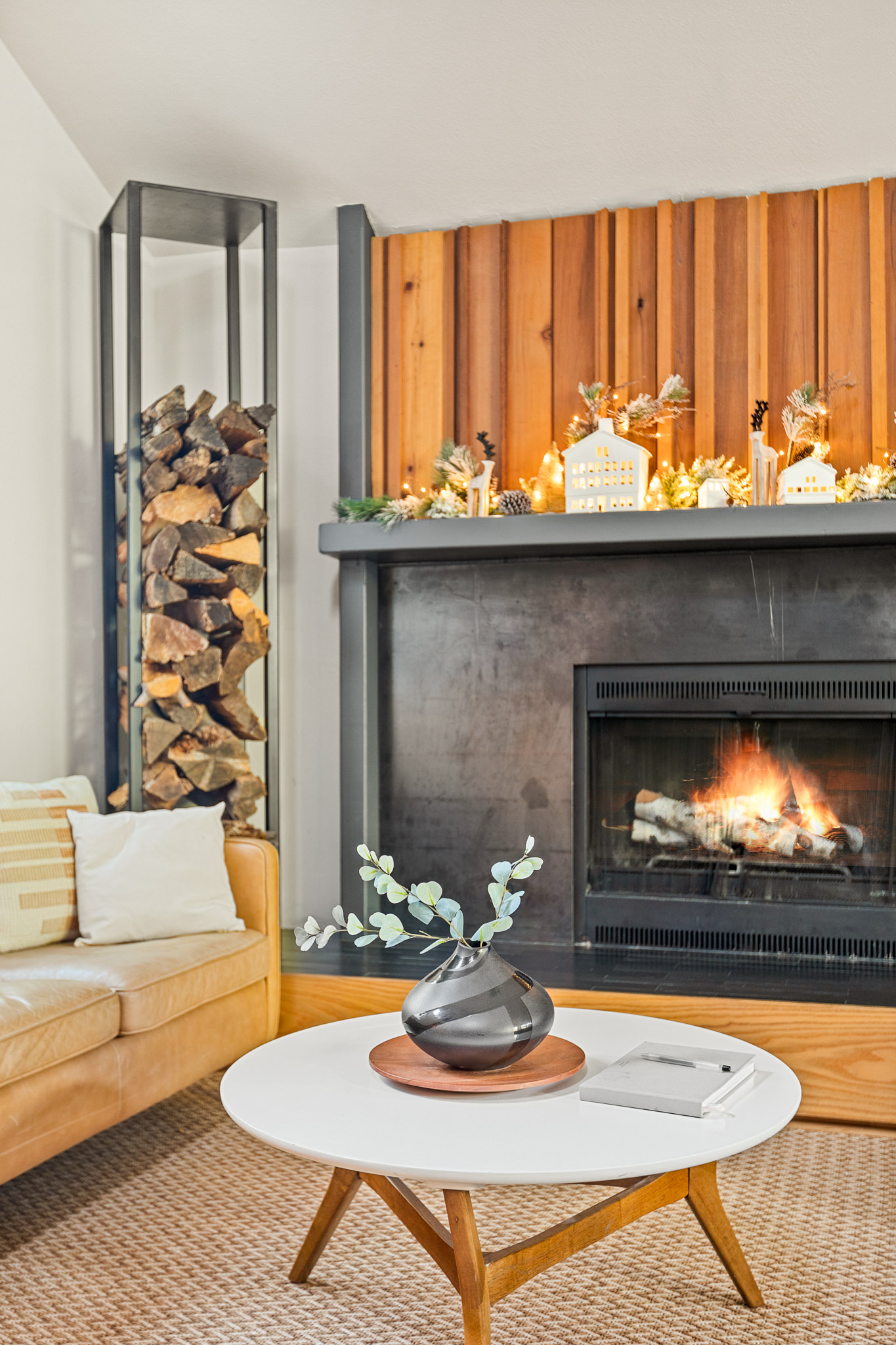 Cozy holiday fireplace with warm lighting, festive decor, and modern wood accents—perfect for a relaxing winter stay.