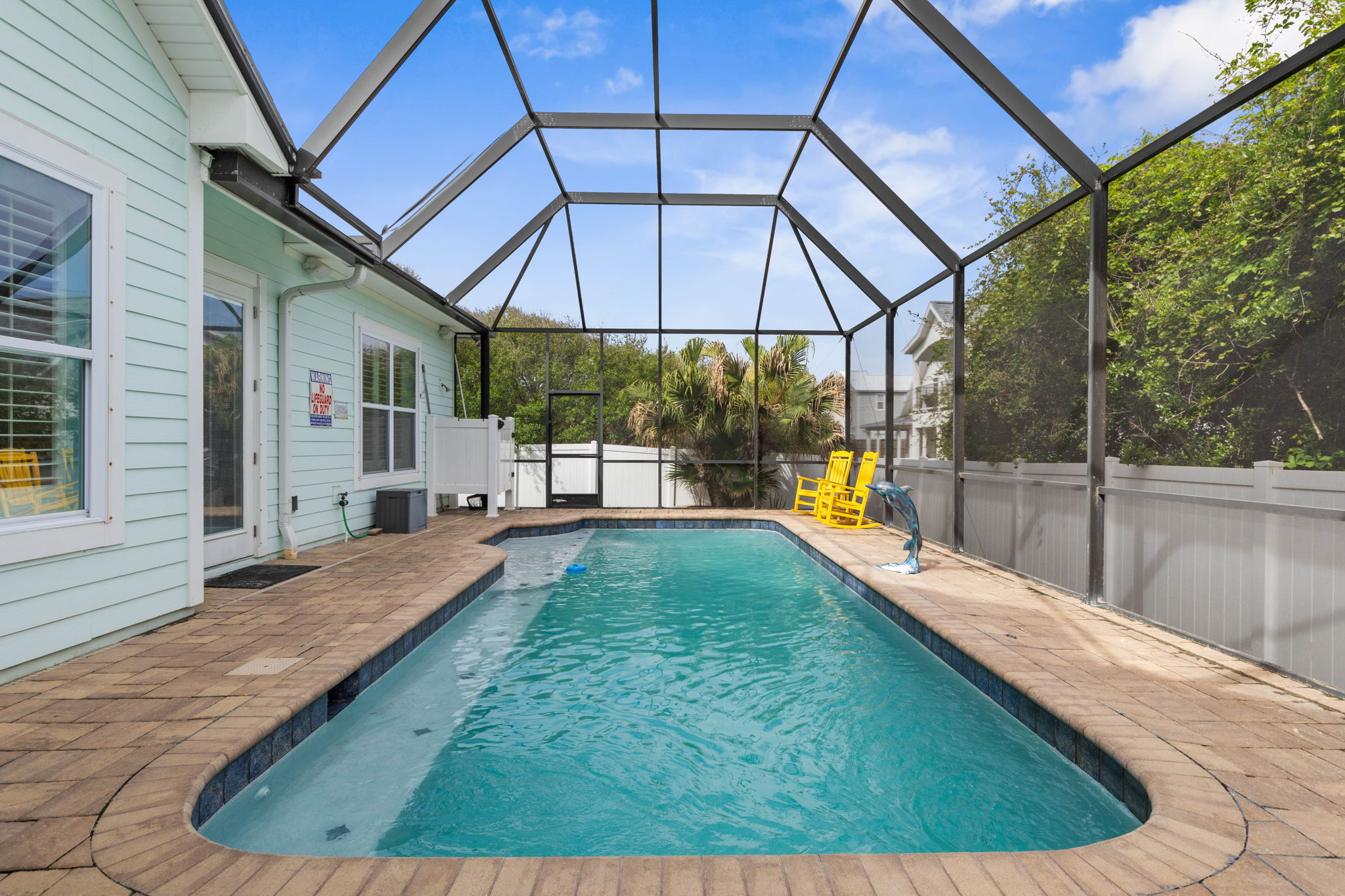 Start with coffee in the yellow rockers, cool off in your private screened pool, and let the day unfold at beach pace—sun, swims, salty air, and that quiet feeling you only get when vacation finally begins.