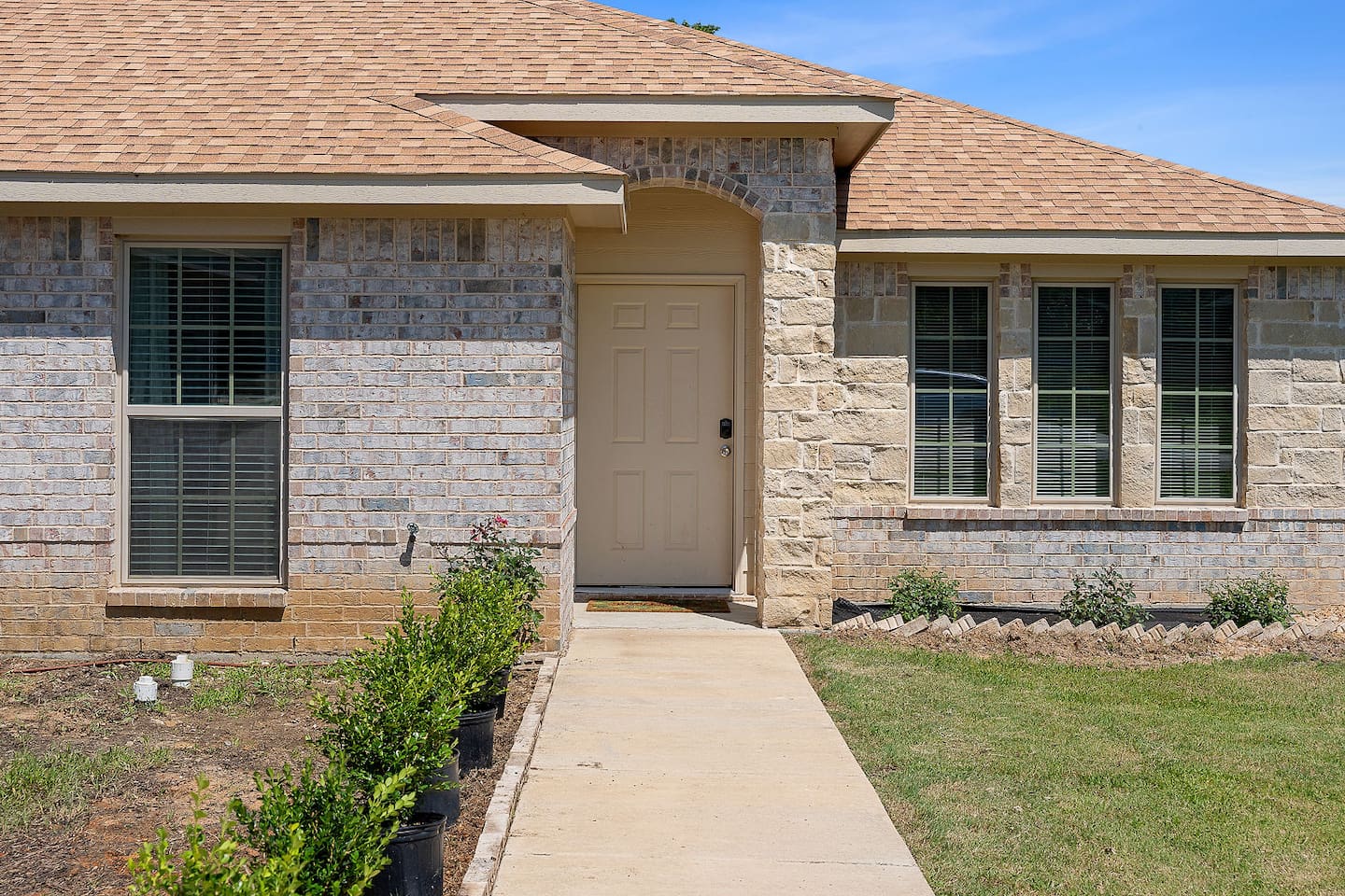 Approach a well-maintained entrance path leading to a welcoming front door.