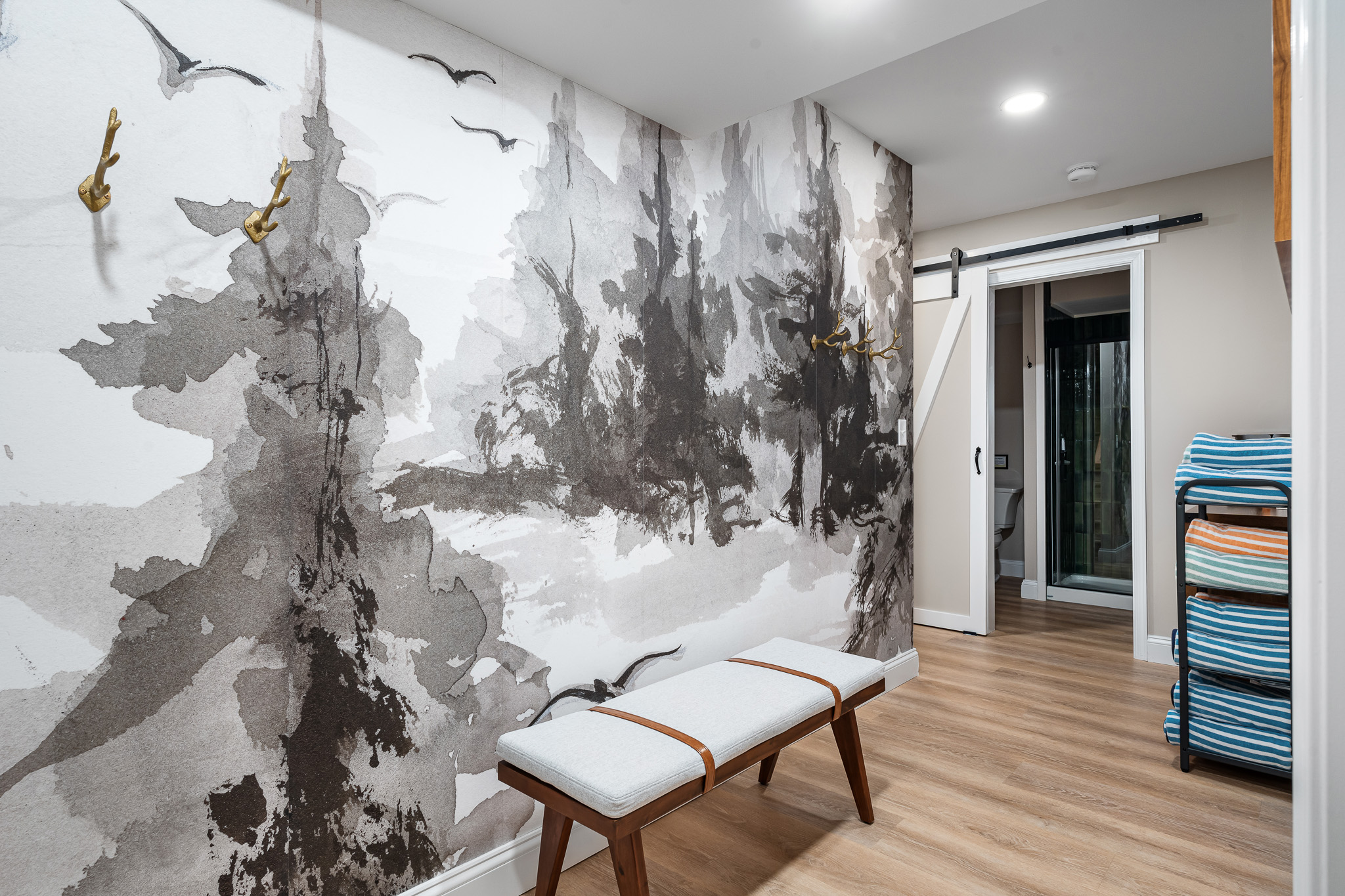 A peaceful transition space with a watercolor forest mural — the perfect spot to drop your gear and unwind.