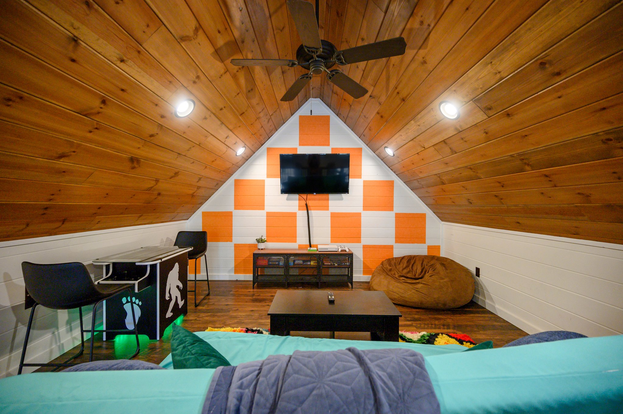 Disco Cowboy | Game loft with air hockey, Xbox and lounge seating. A twin daybed and trundle replaced the old futon; the cabin maximum remains 10 guests, with two king beds and six twin bunks as the advertised sleeping setup.