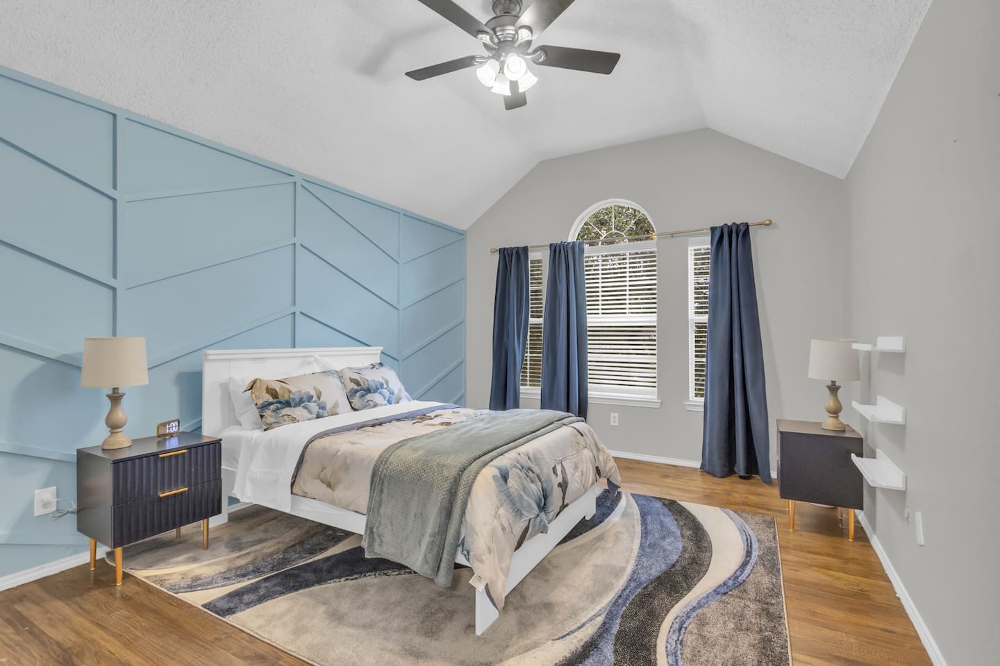 Spacious guest bedroom featuring a comfortable queen bed, room-darkening blinds, ceiling fan, fresh bed linens, hangers, and a quiet setting ideal for restful sleep.