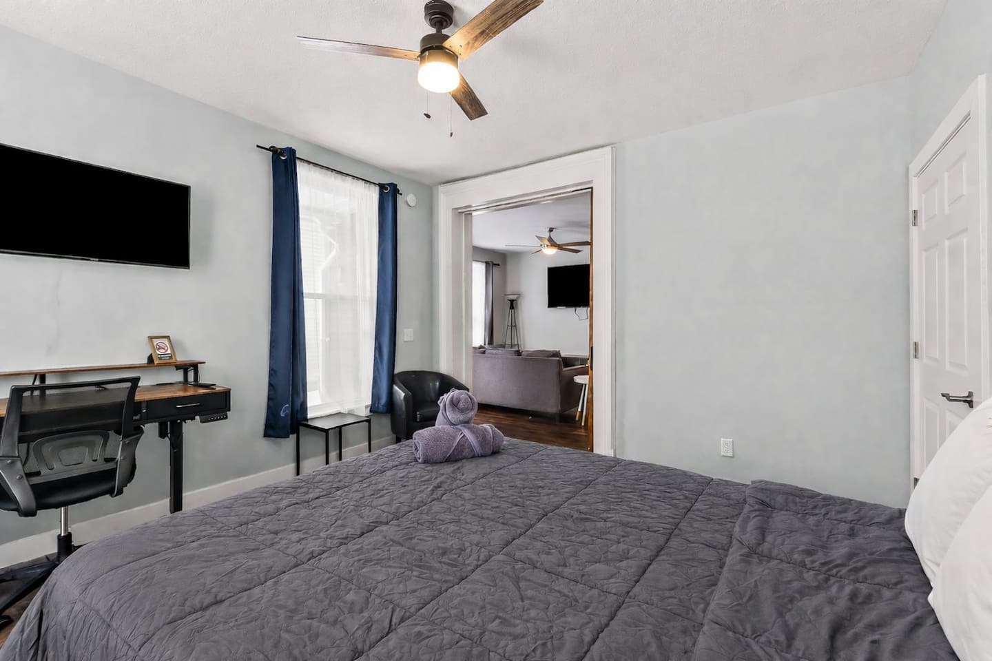 Bedroom workspace setup with desk, chair, wall-mounted TV, and peaceful views—ideal for remote work.