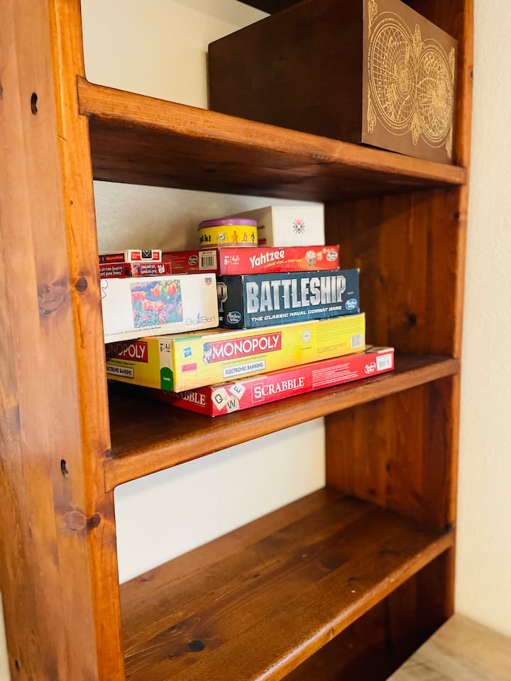 A collection of board games and puzzles lines the bookshelf, inviting creativity, friendly competition, and cozy moments indoors for all ages.
